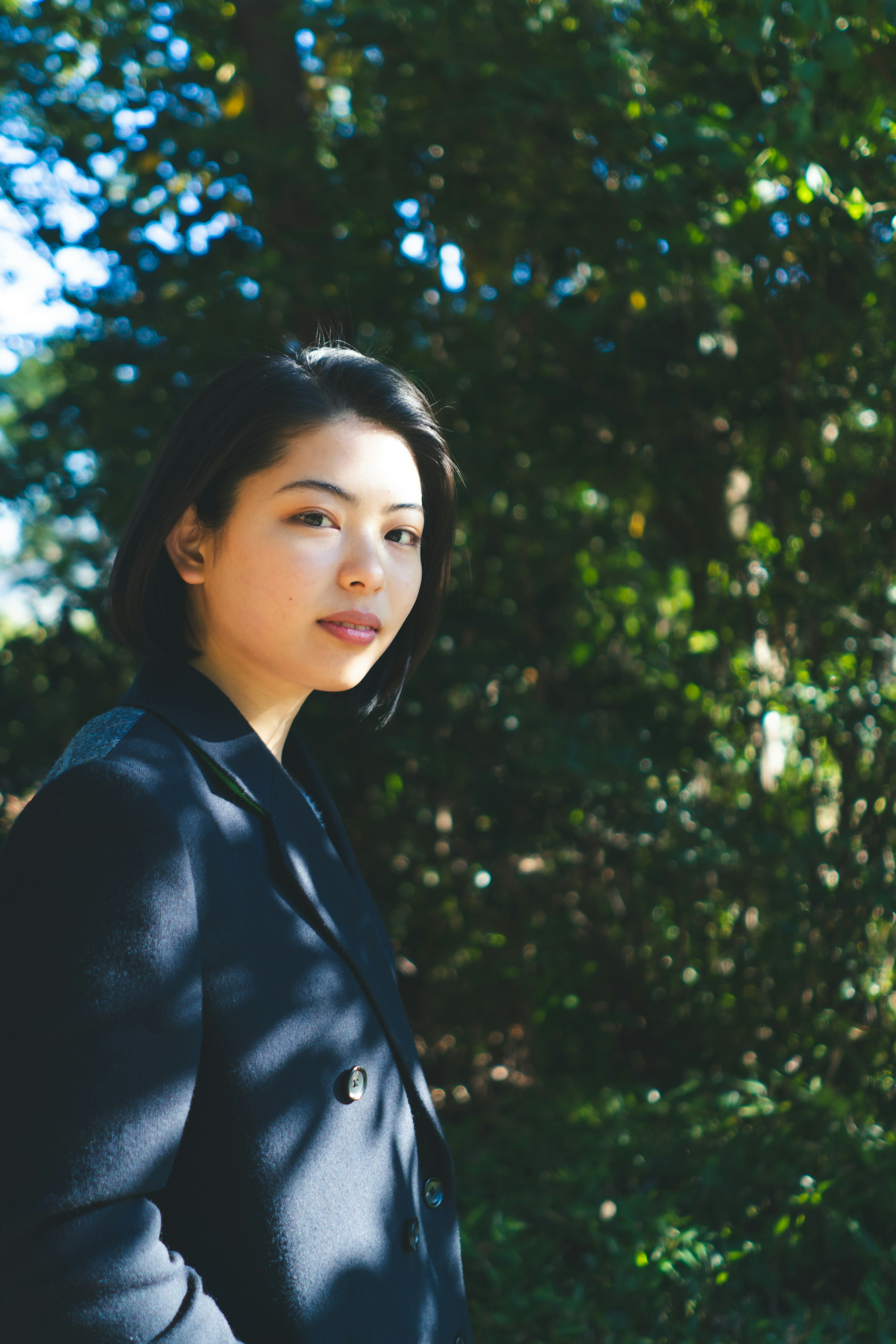 Portrait of a woman standing in front of a green background