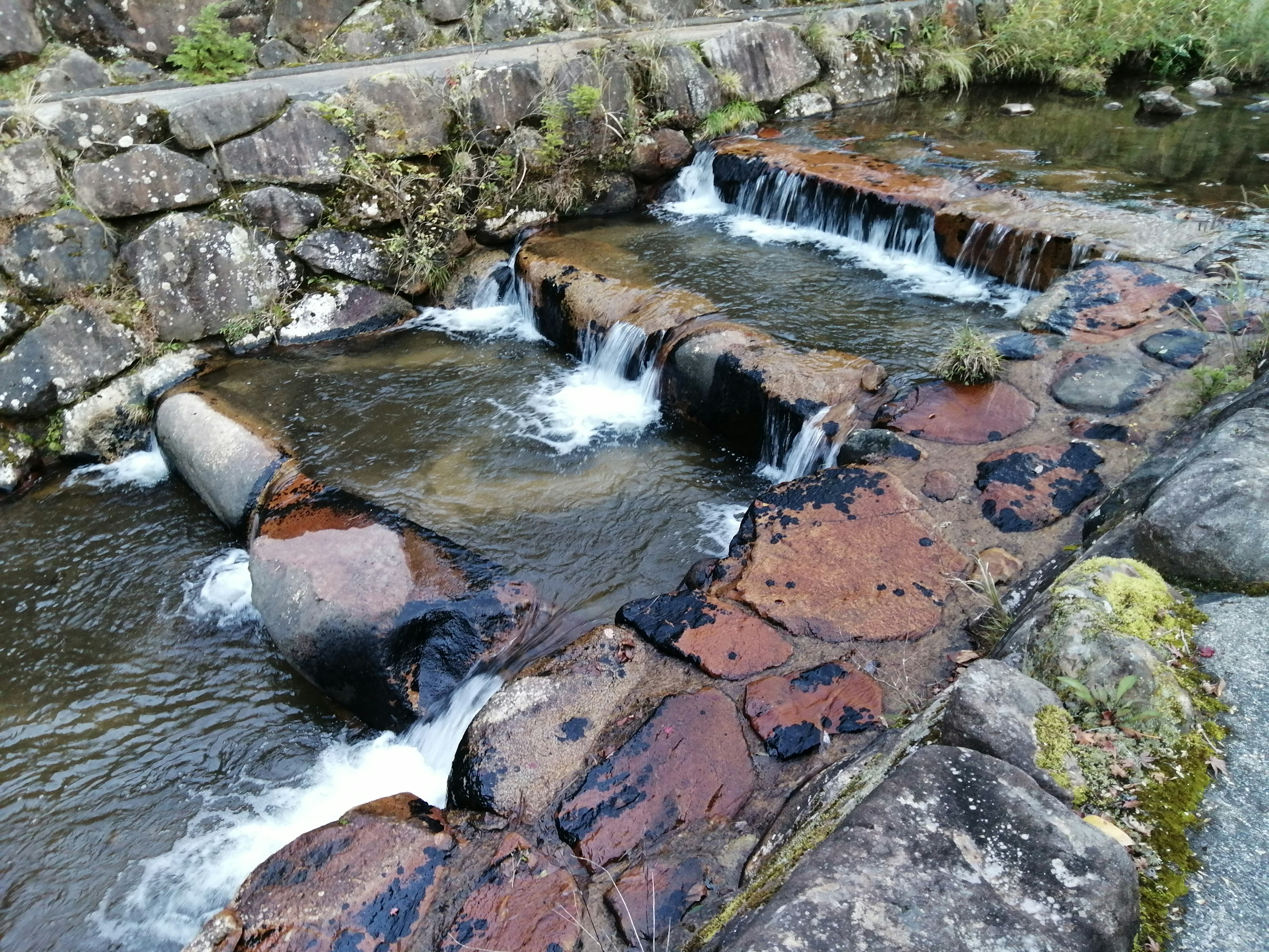 Una vista panoramica di un torrente con dighe di pietra e acqua che scorre