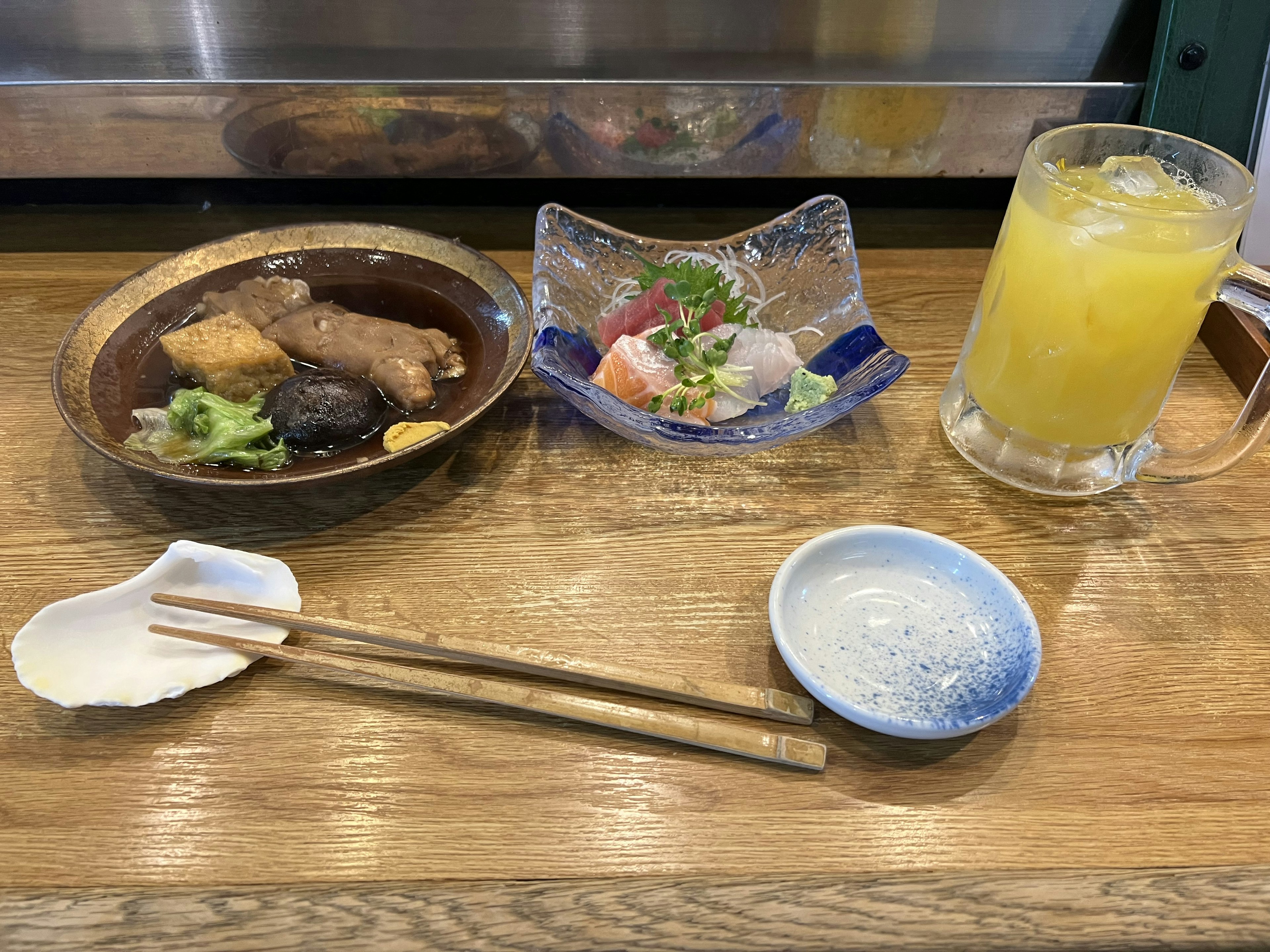 日本餐點，包含各式菜餚、新鮮刺身和柑橘飲料