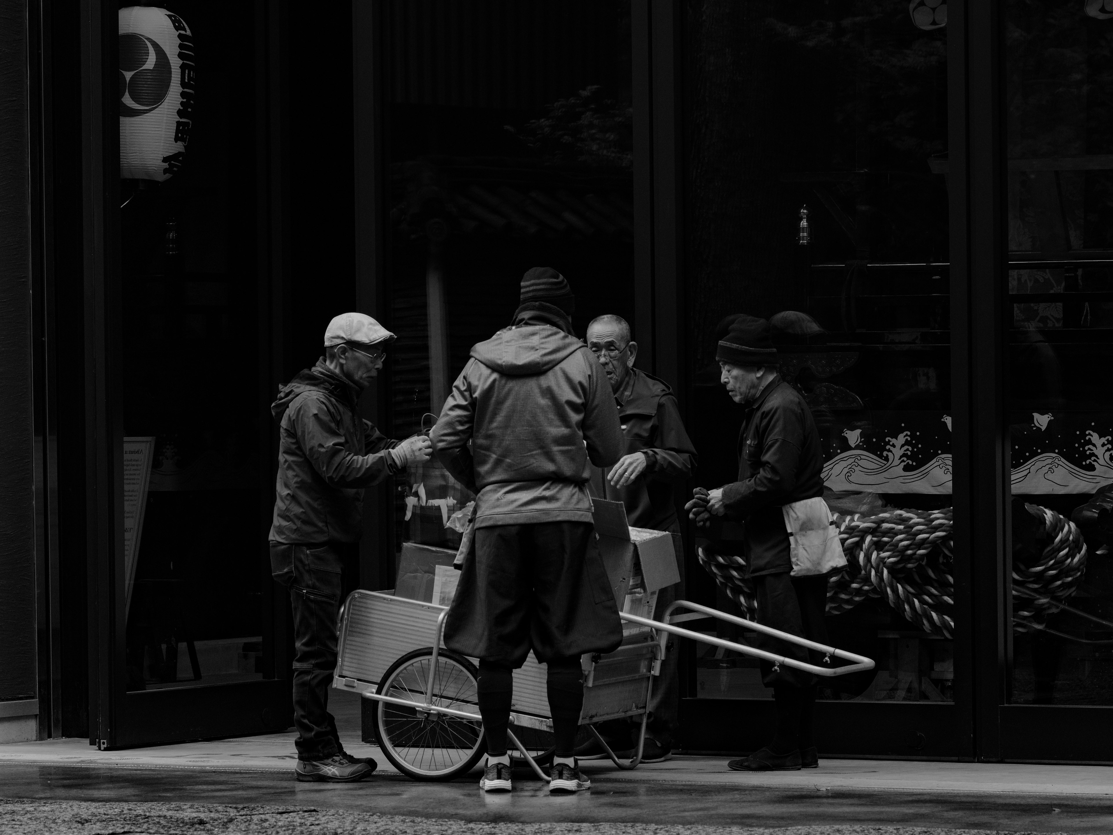 Foto en blanco y negro de personas negociando frente a una tienda