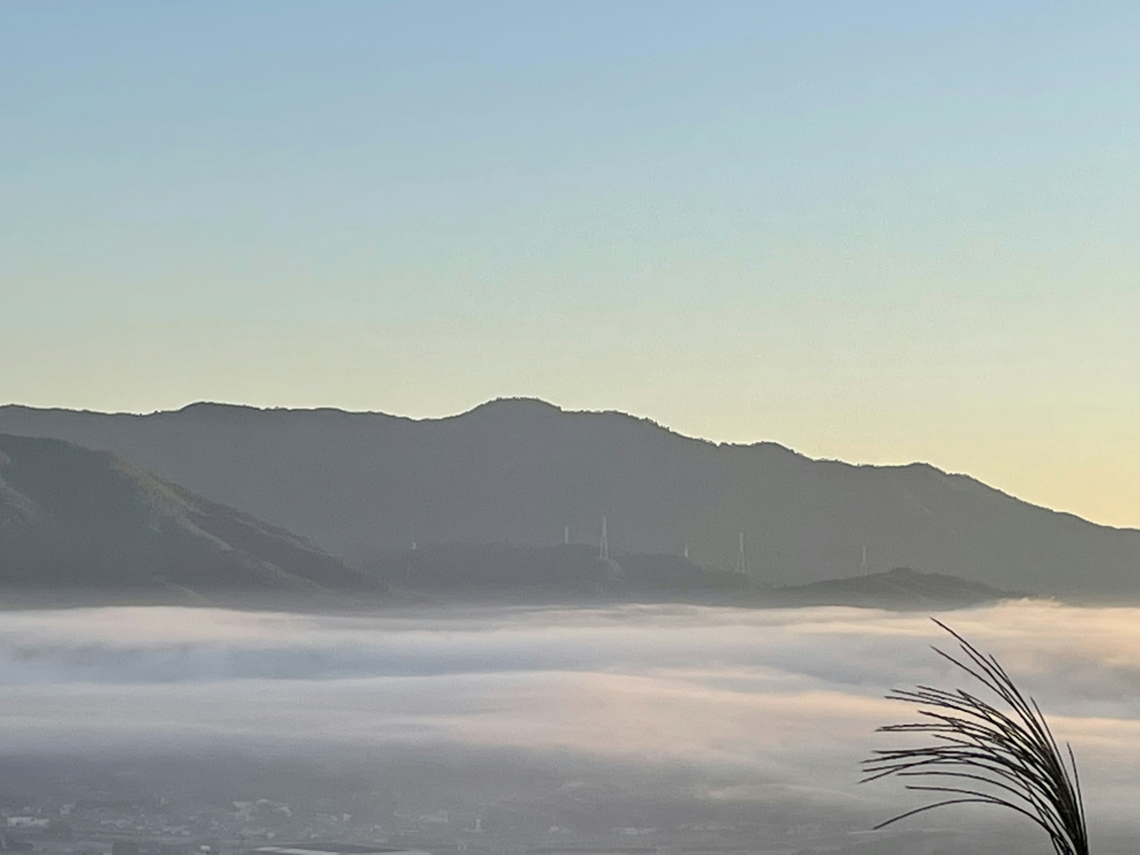 Fog-covered mountains with a clear blue sky