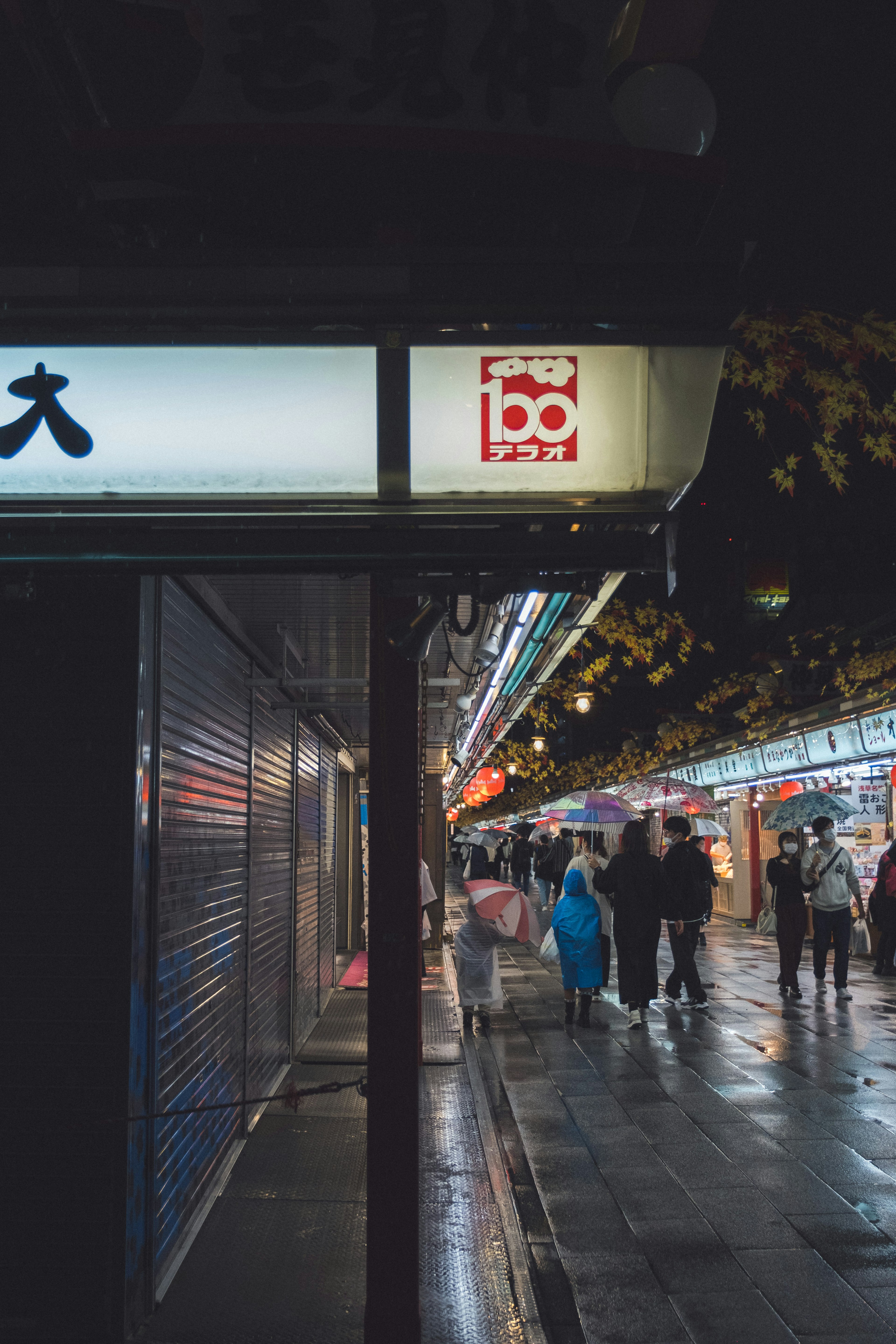 Scène de rue nocturne avec des magasins et des gens marchant