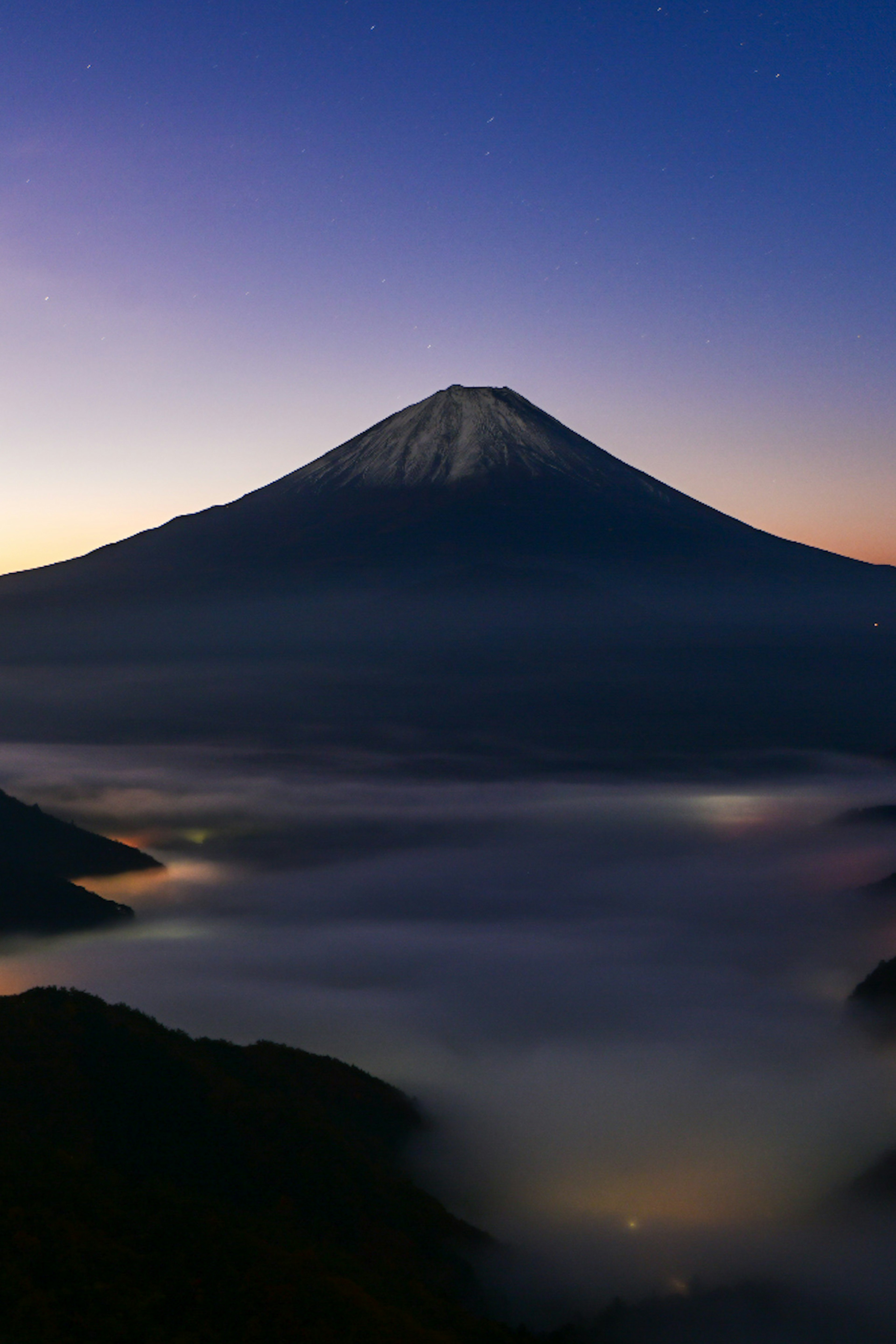 富士山の夜明けの風景、雪に覆われた山頂、霧に包まれた谷