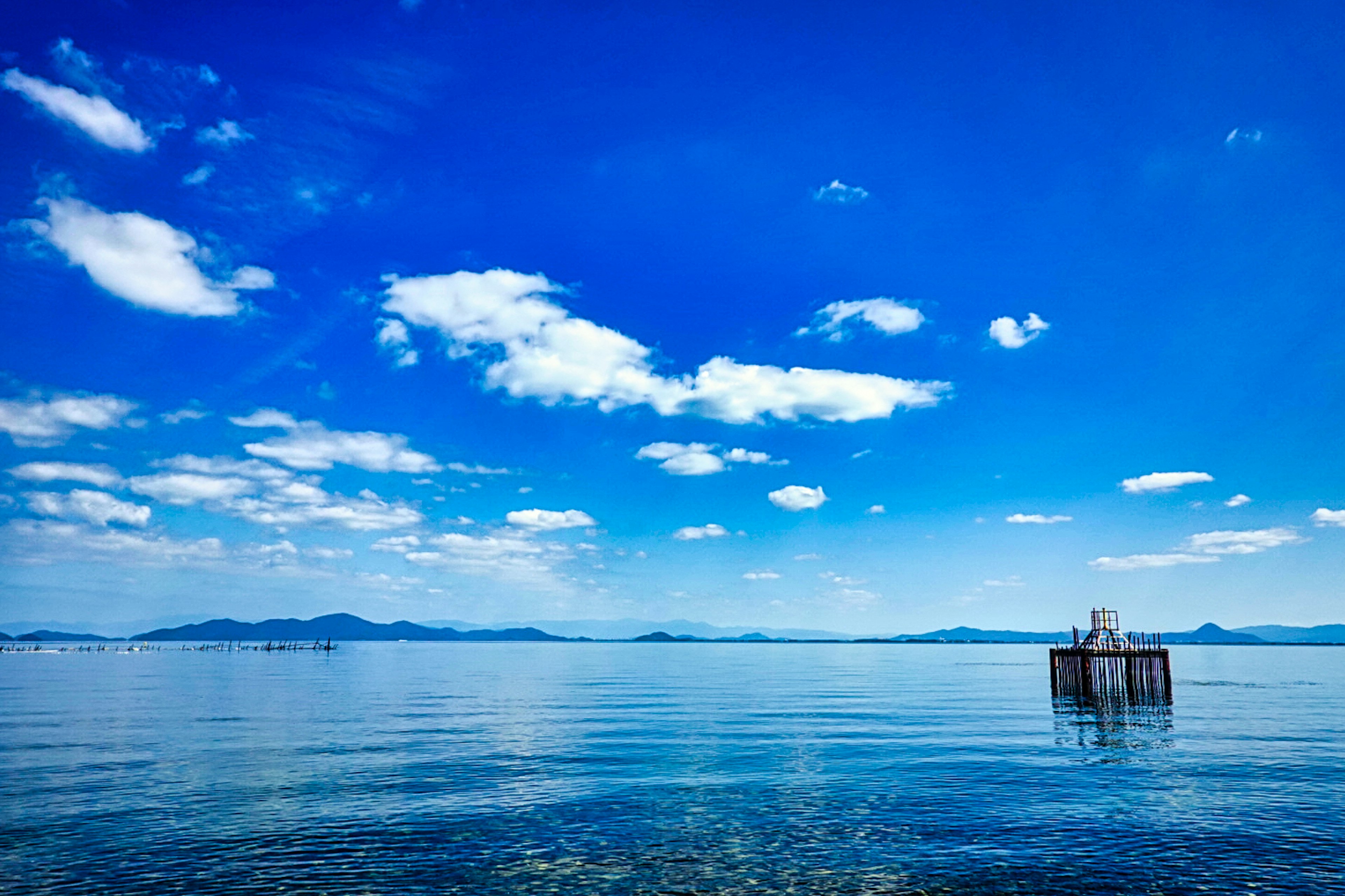 Pemandangan langit biru dan laut tenang dengan dermaga