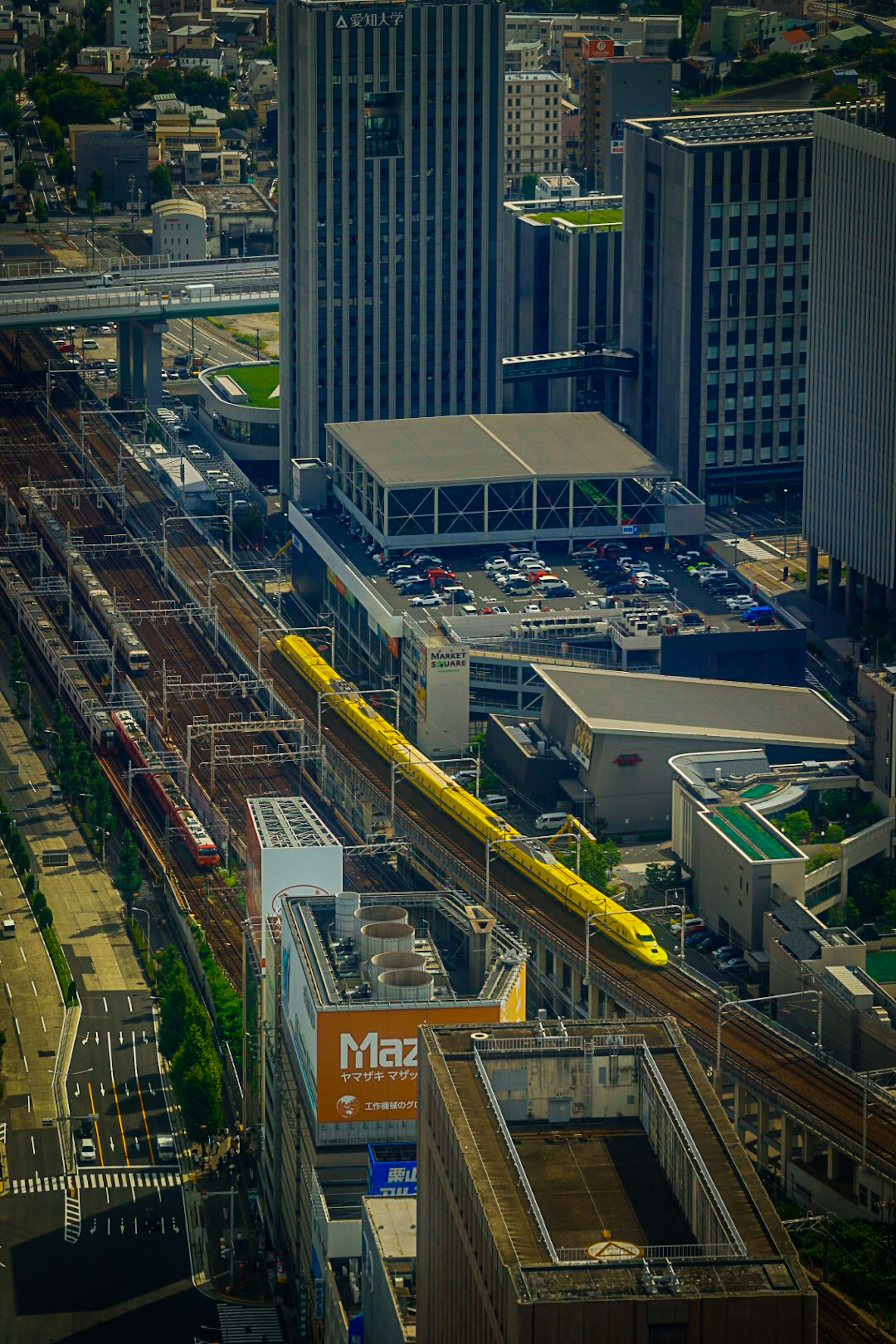 都市の鉄道駅と高層ビルの空撮写真