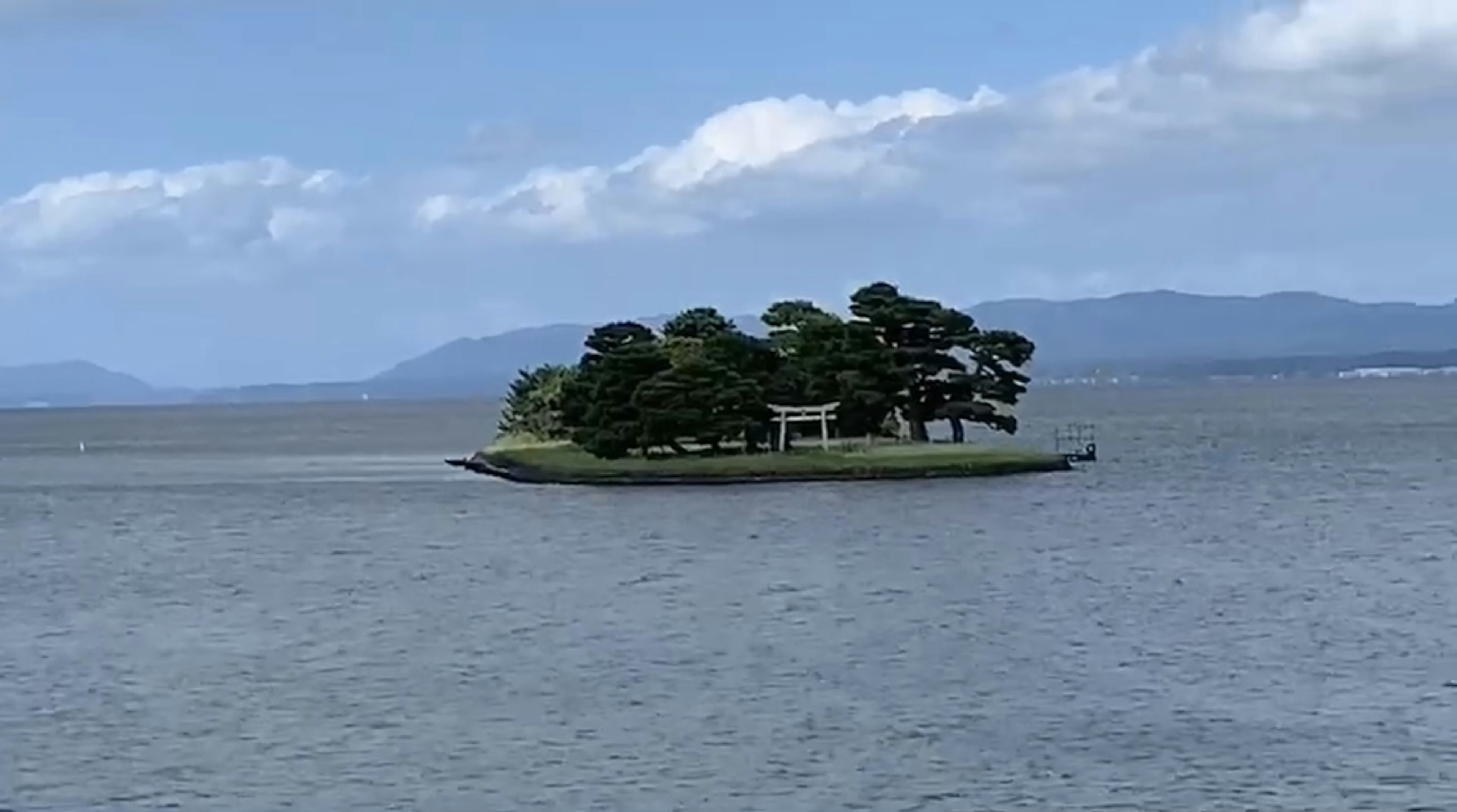 Pulau kecil dengan pepohonan rimbun di laut