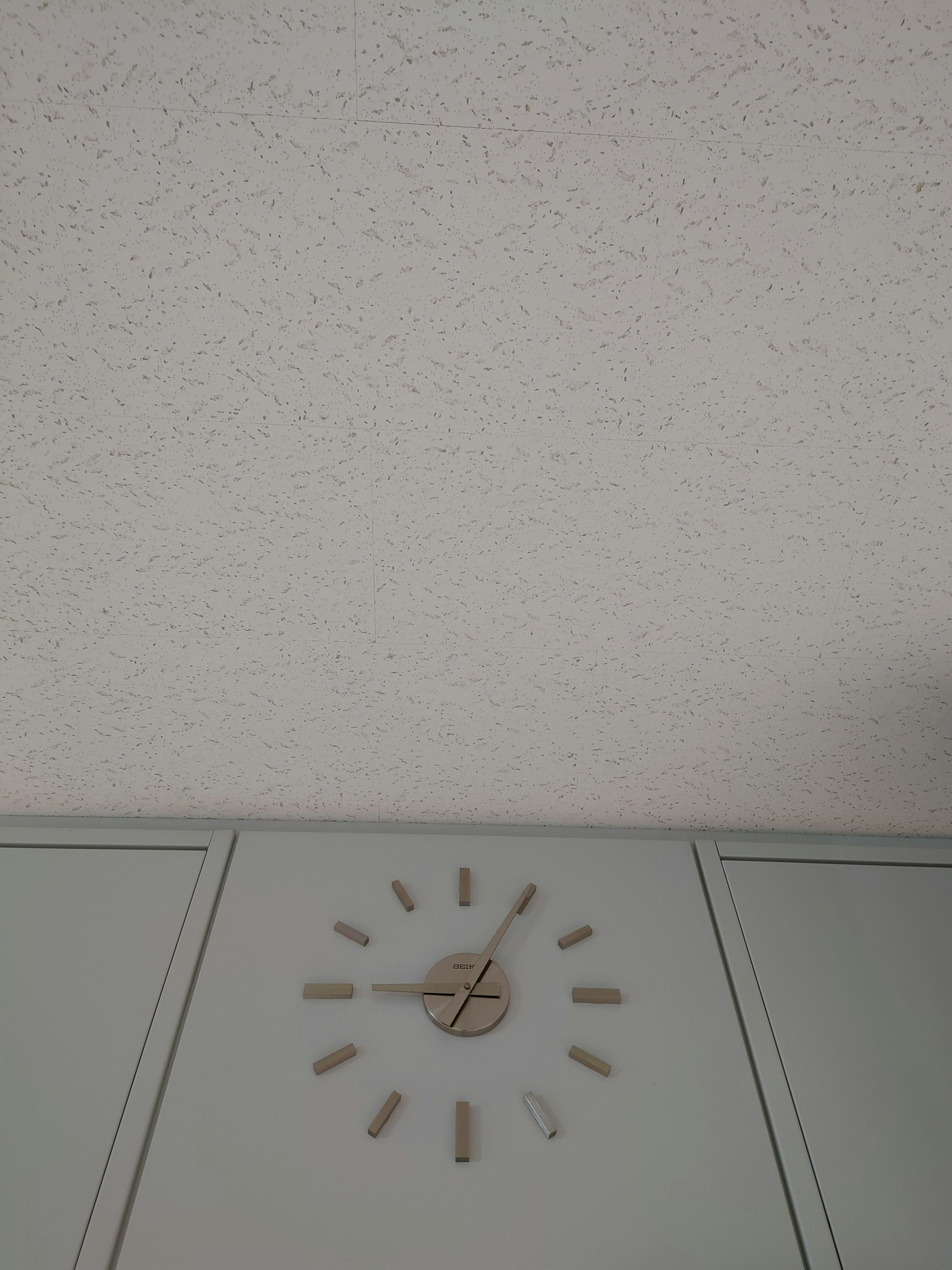 Simple clock on a white wall with minimalist design