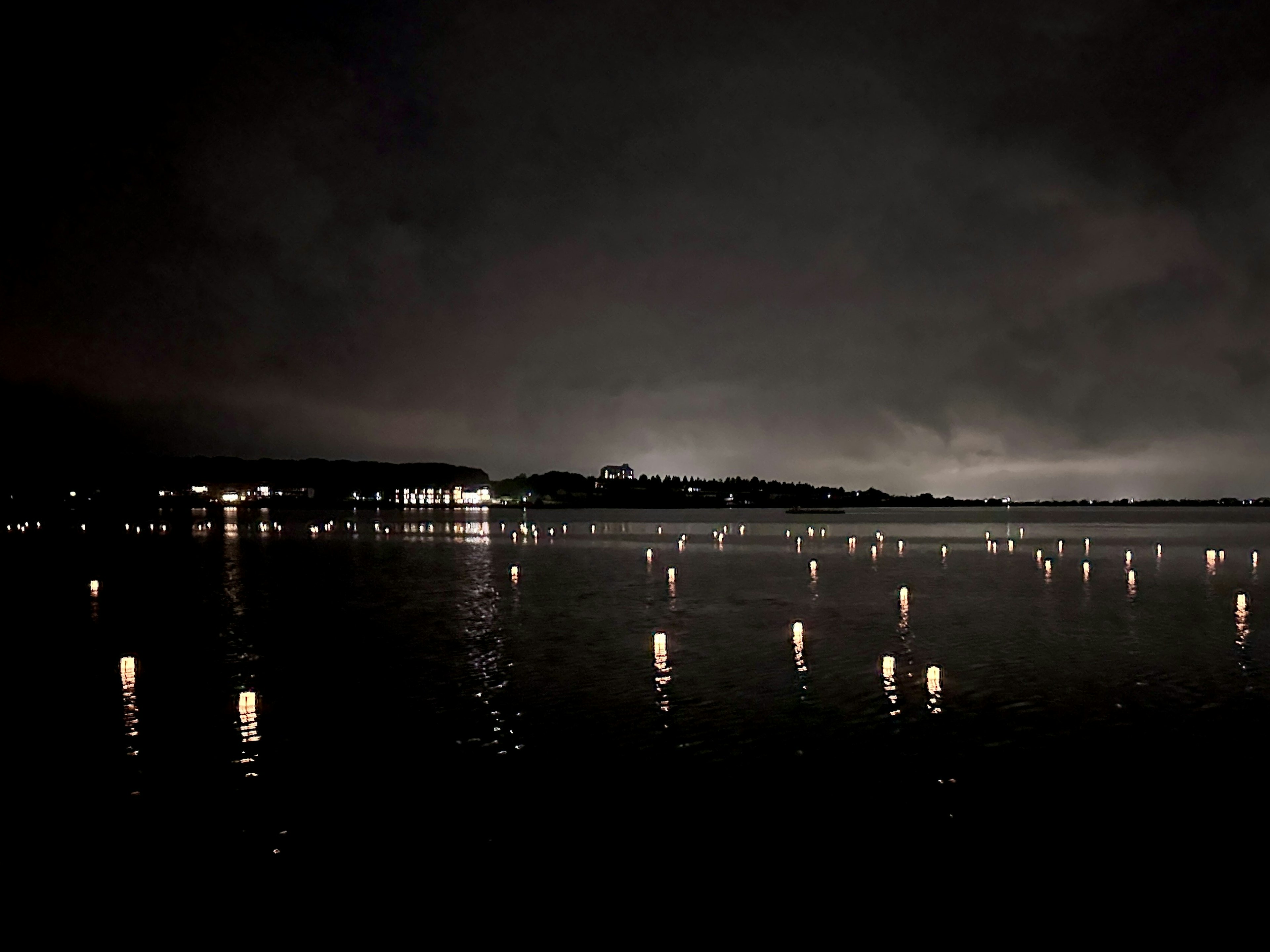 Nächtliche Aussicht auf einen See mit Lichtreflexionen