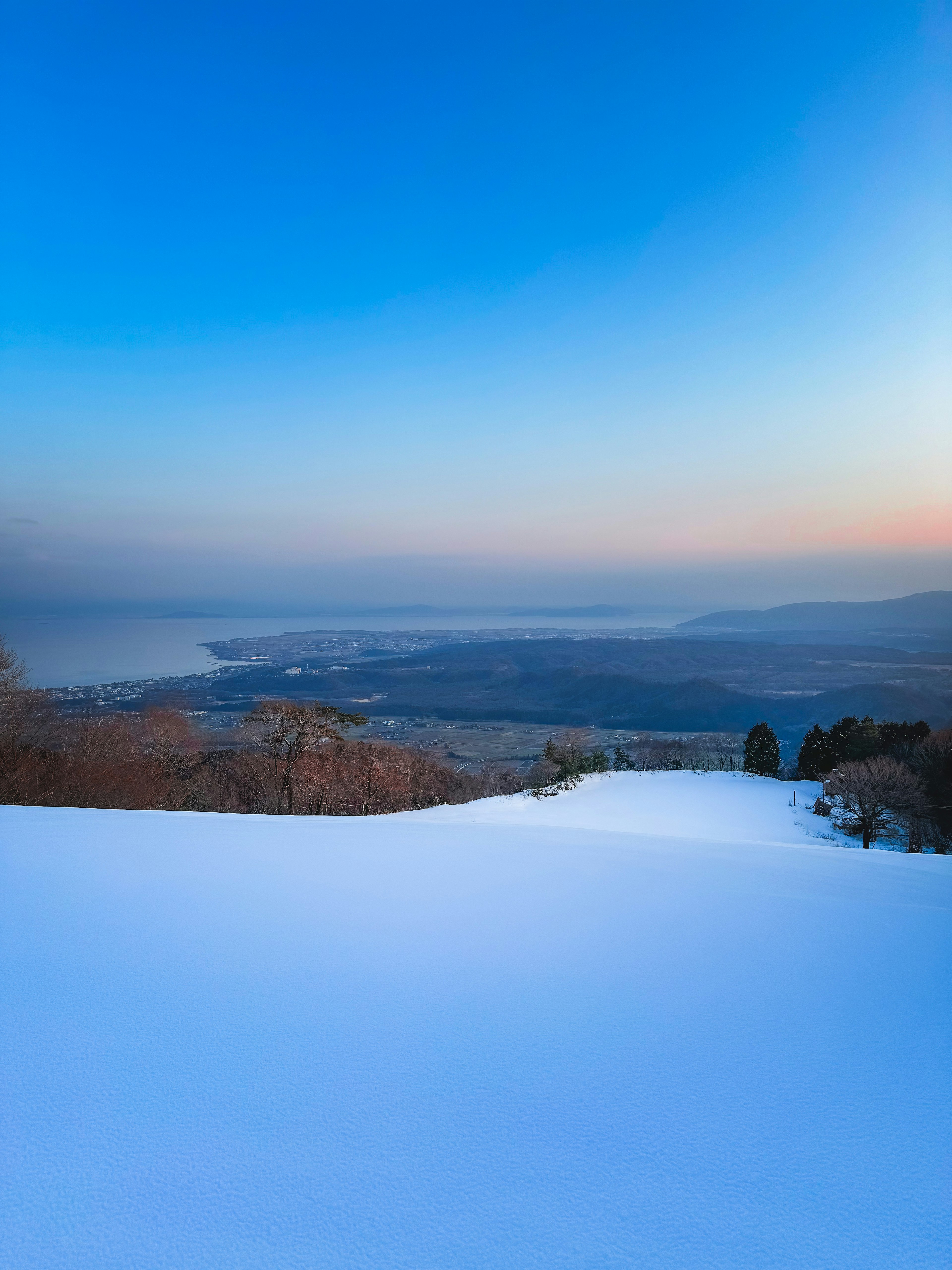 雪に覆われた風景と青い空の夕暮れ