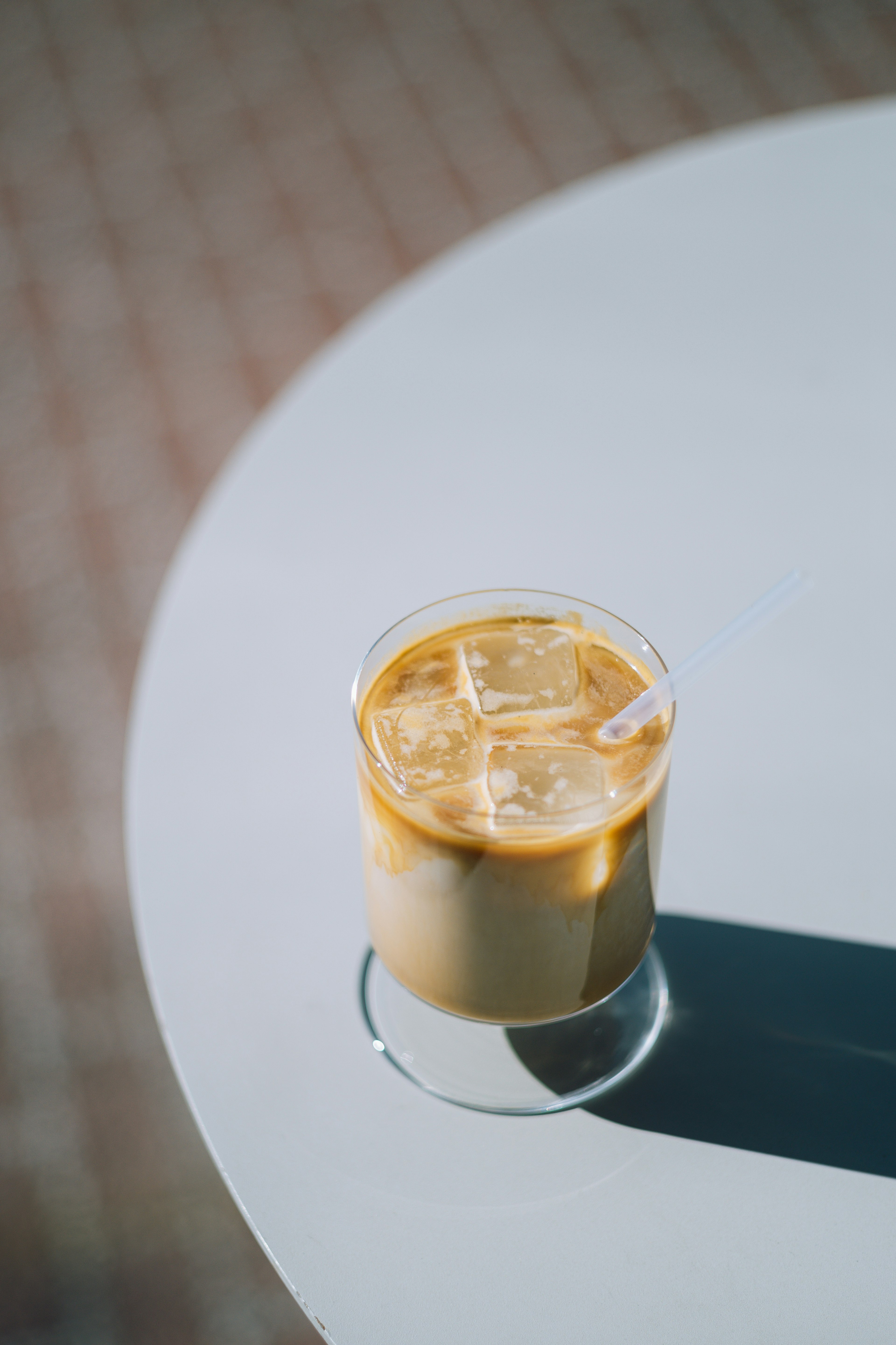 Café helado servido en un vaso transparente con hielo y una pajita