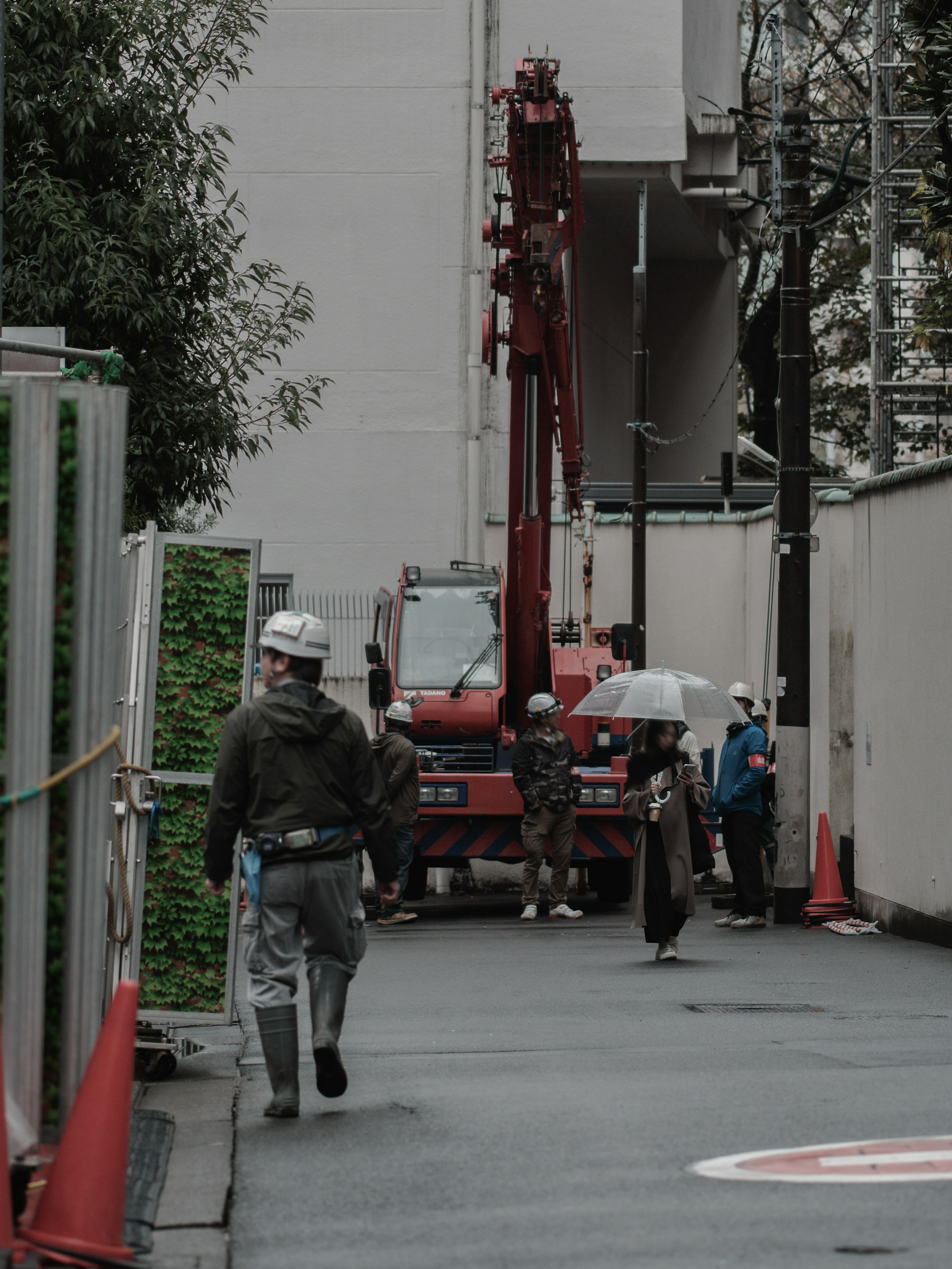 Construction site with workers and a red crane truck