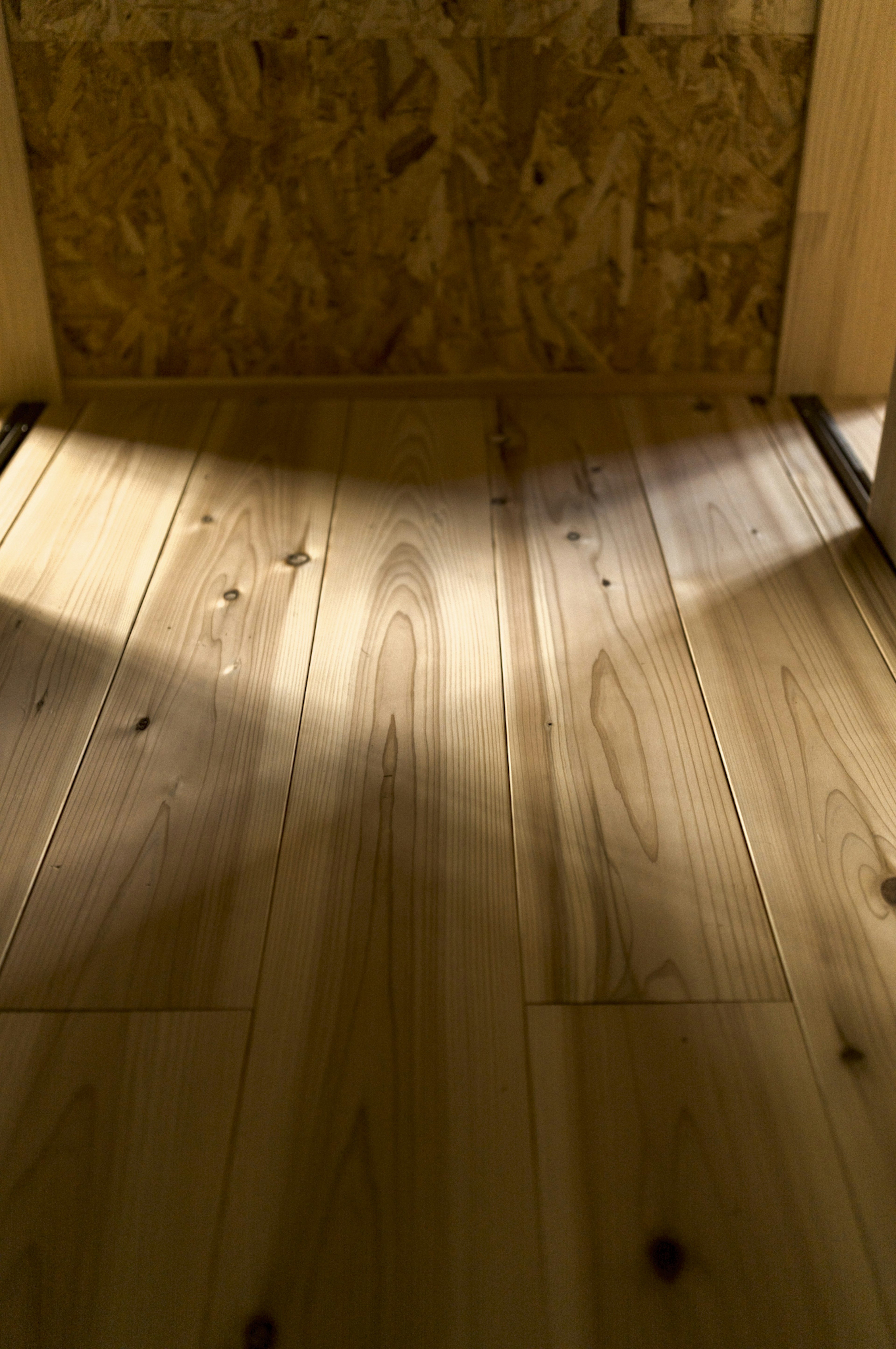 Suelo de madera clara con sombras contrastantes en el interior