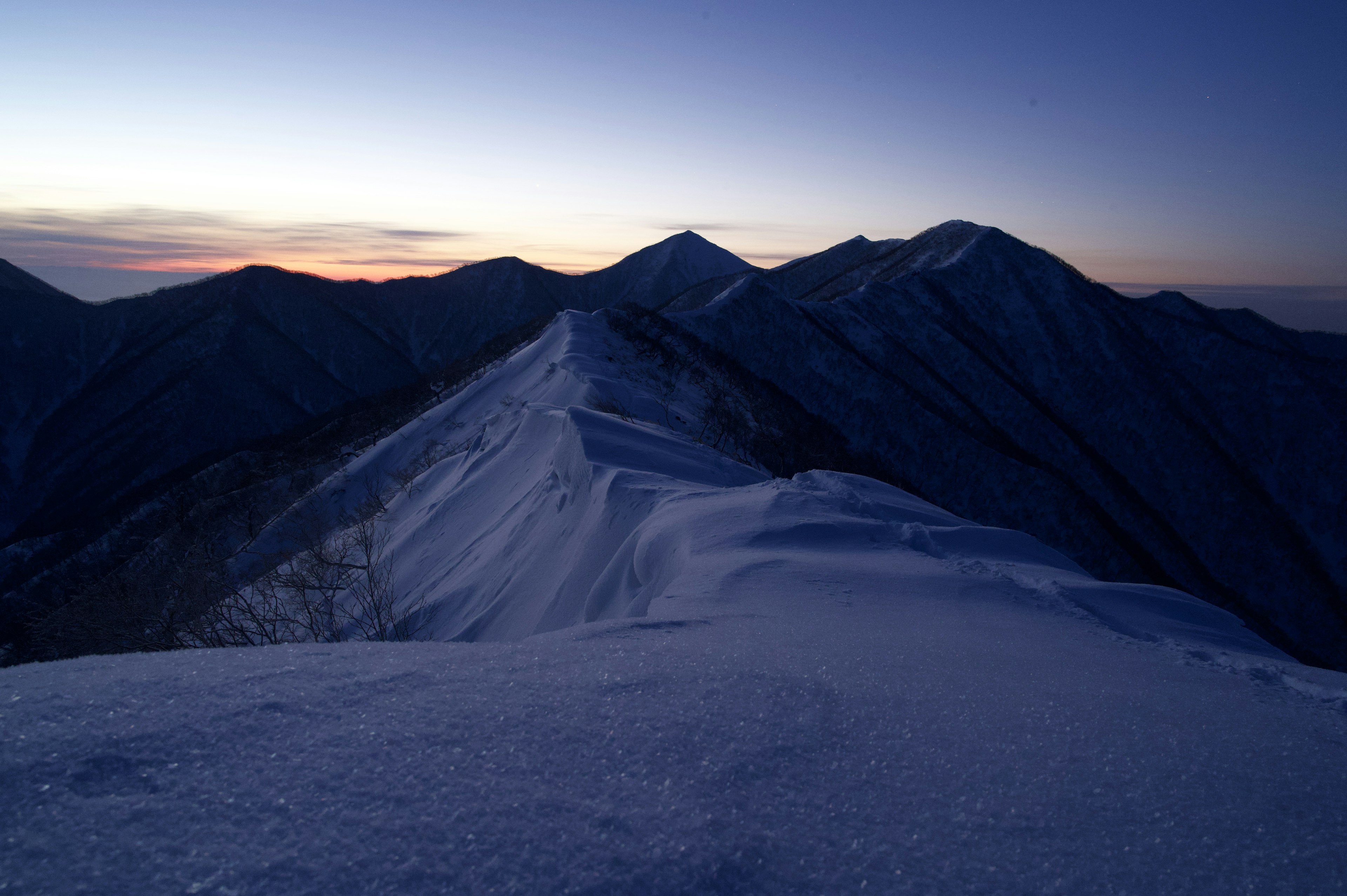 雪に覆われた山脈と夕暮れの空