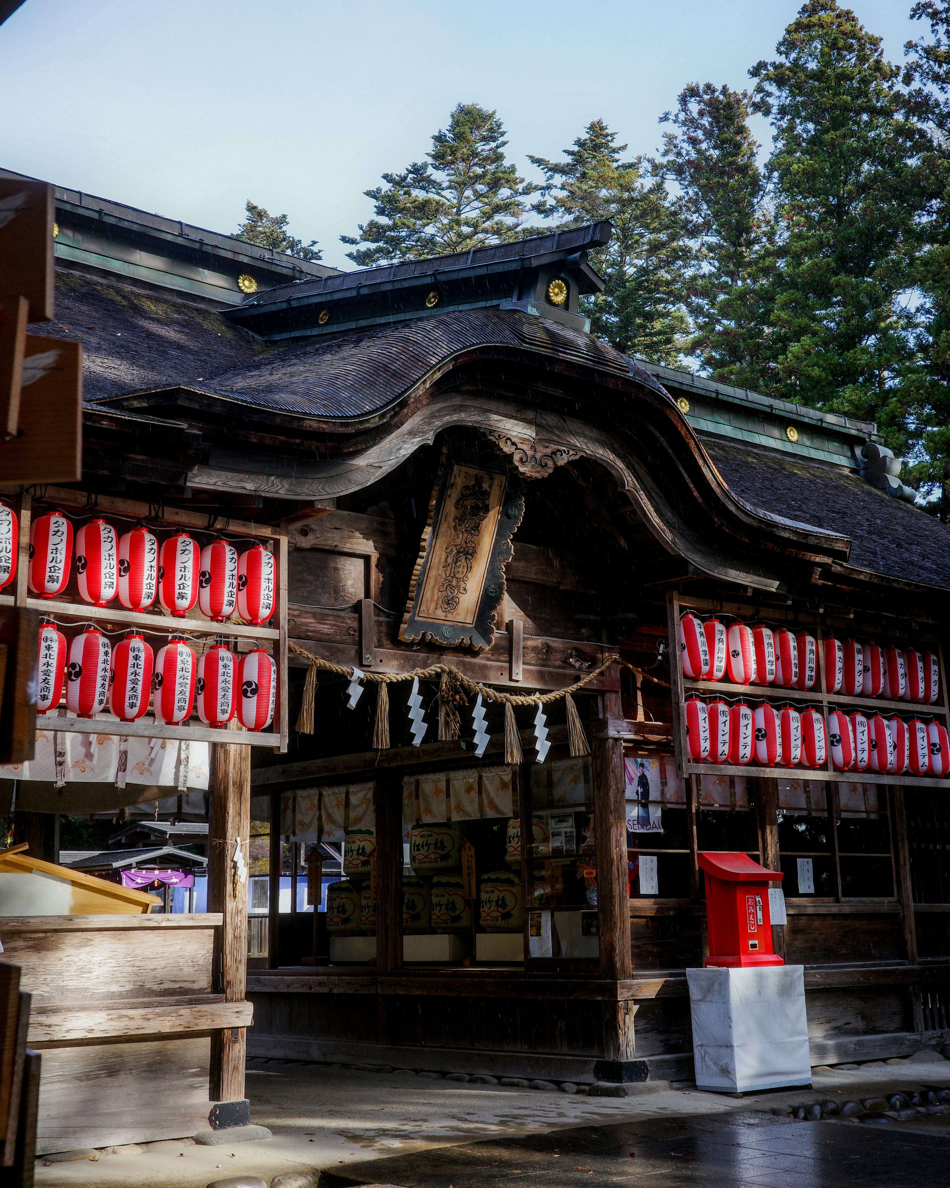 伝統的な神社の建物と赤い提灯が飾られた入口