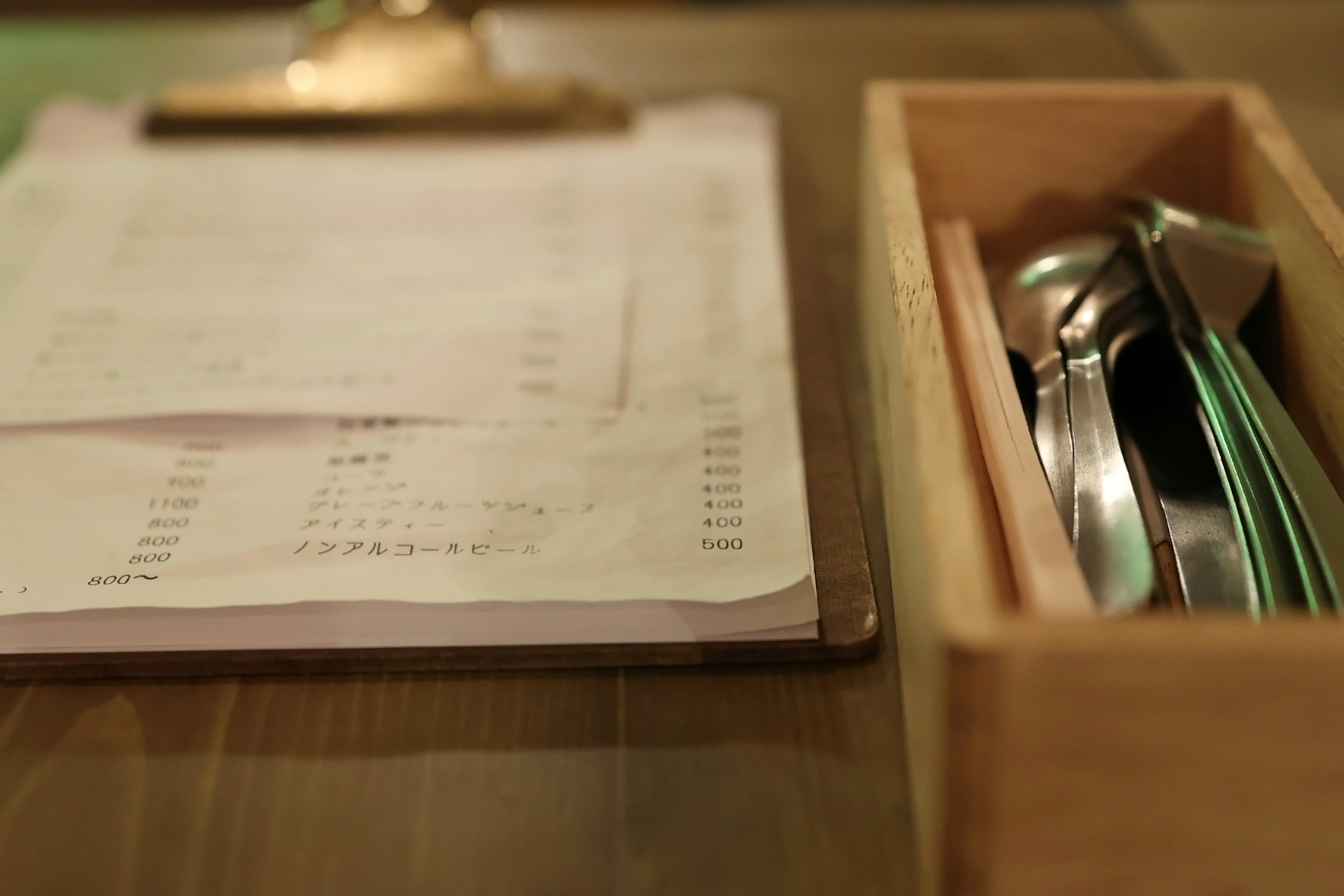 Menu on a table with a wooden box containing cutlery