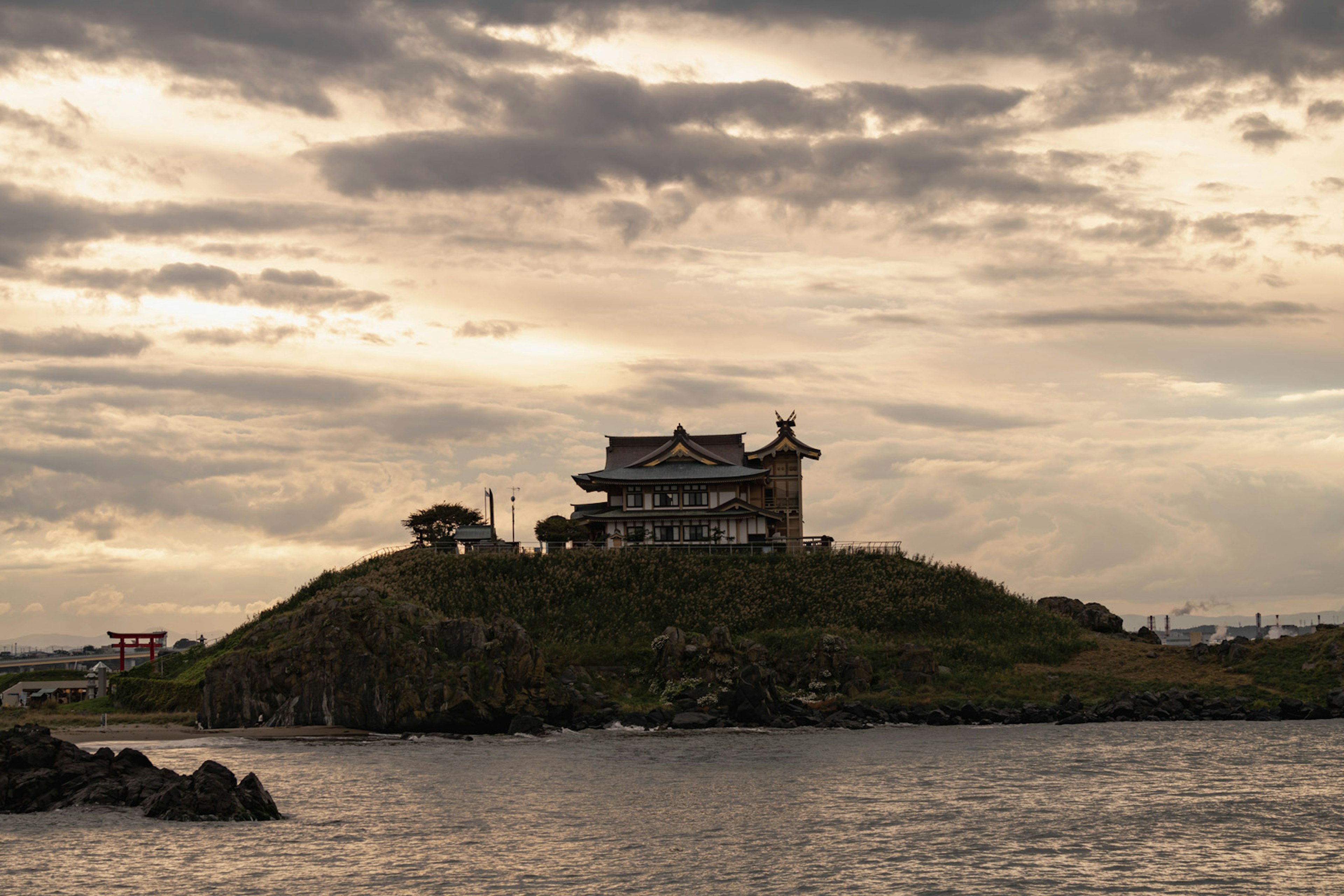 Edificio tradicional en una pequeña isla rodeada de agua con un cielo nublado