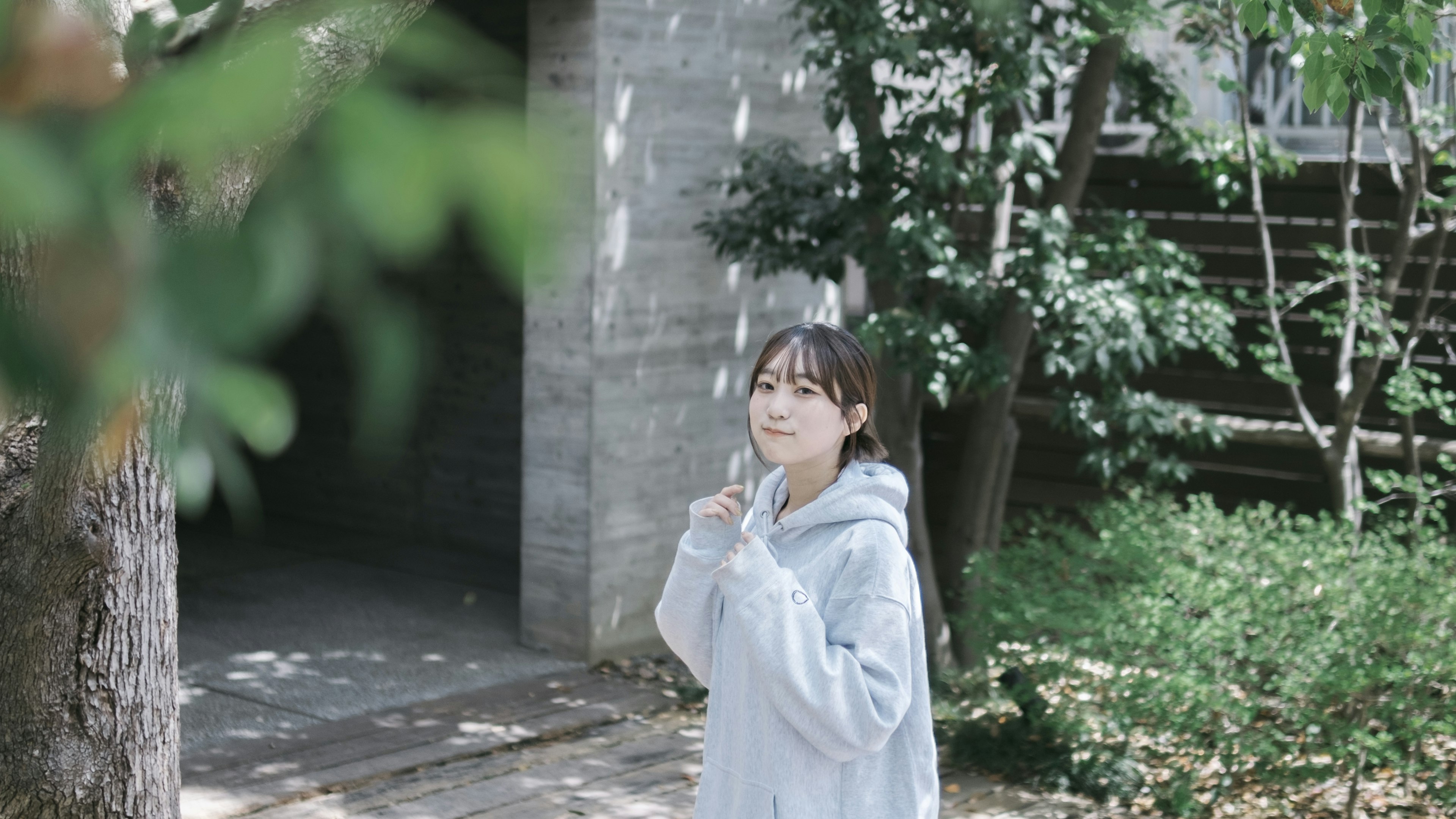 Young woman smiling among green trees