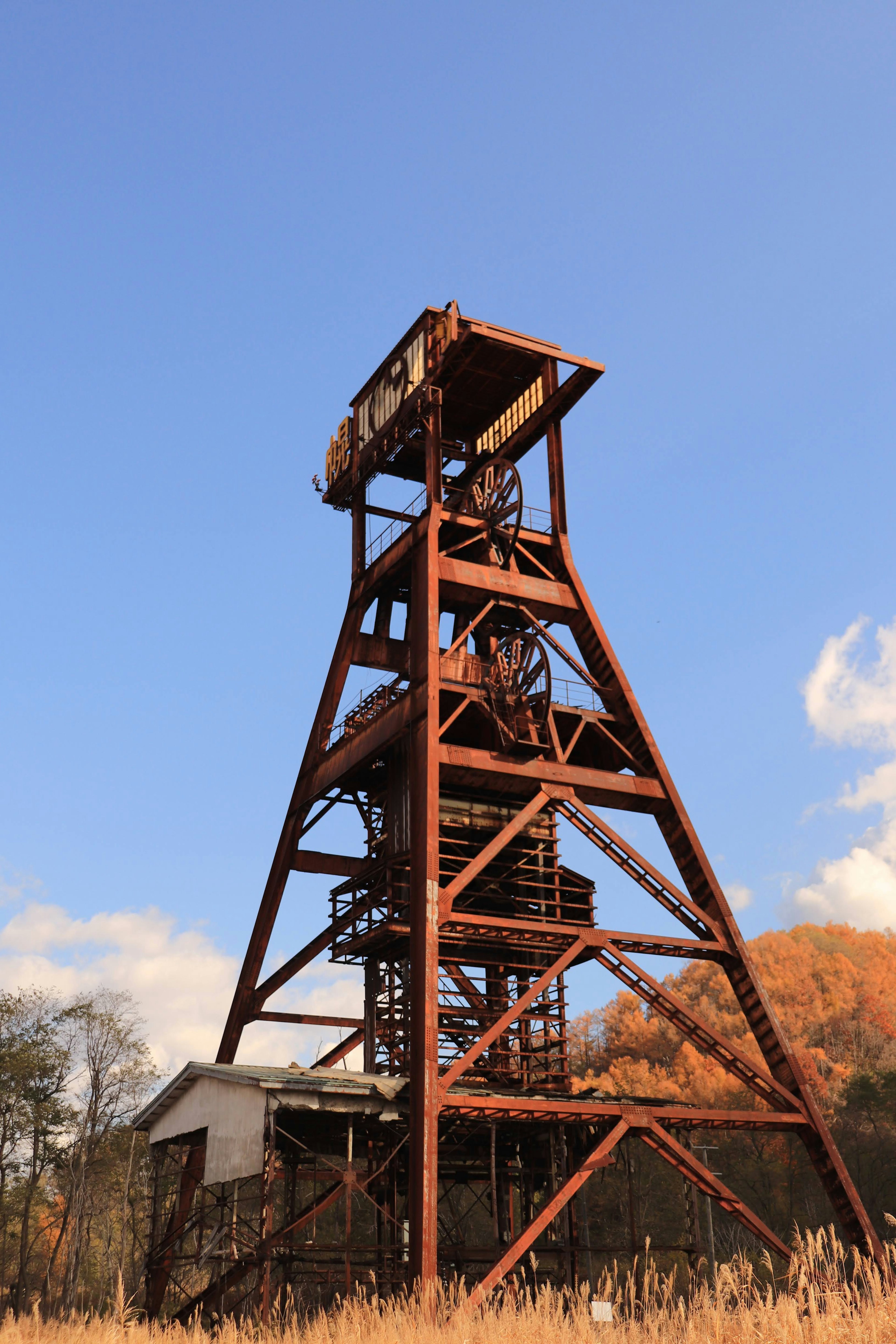 An old mining shaft tower stands under a blue sky