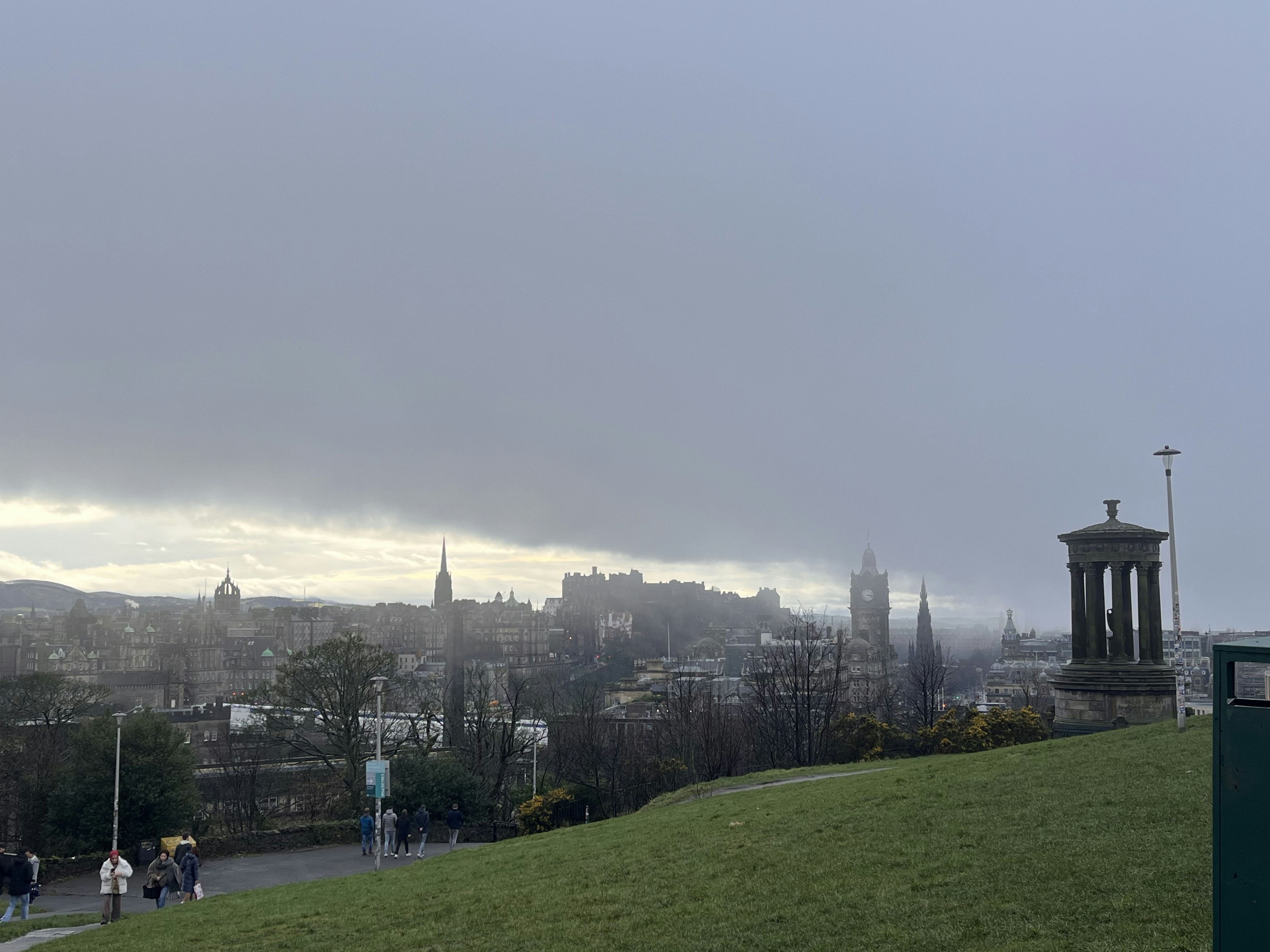 Pemandangan berkabut dari cakrawala Edinburgh dengan bangunan jauh dan monumen