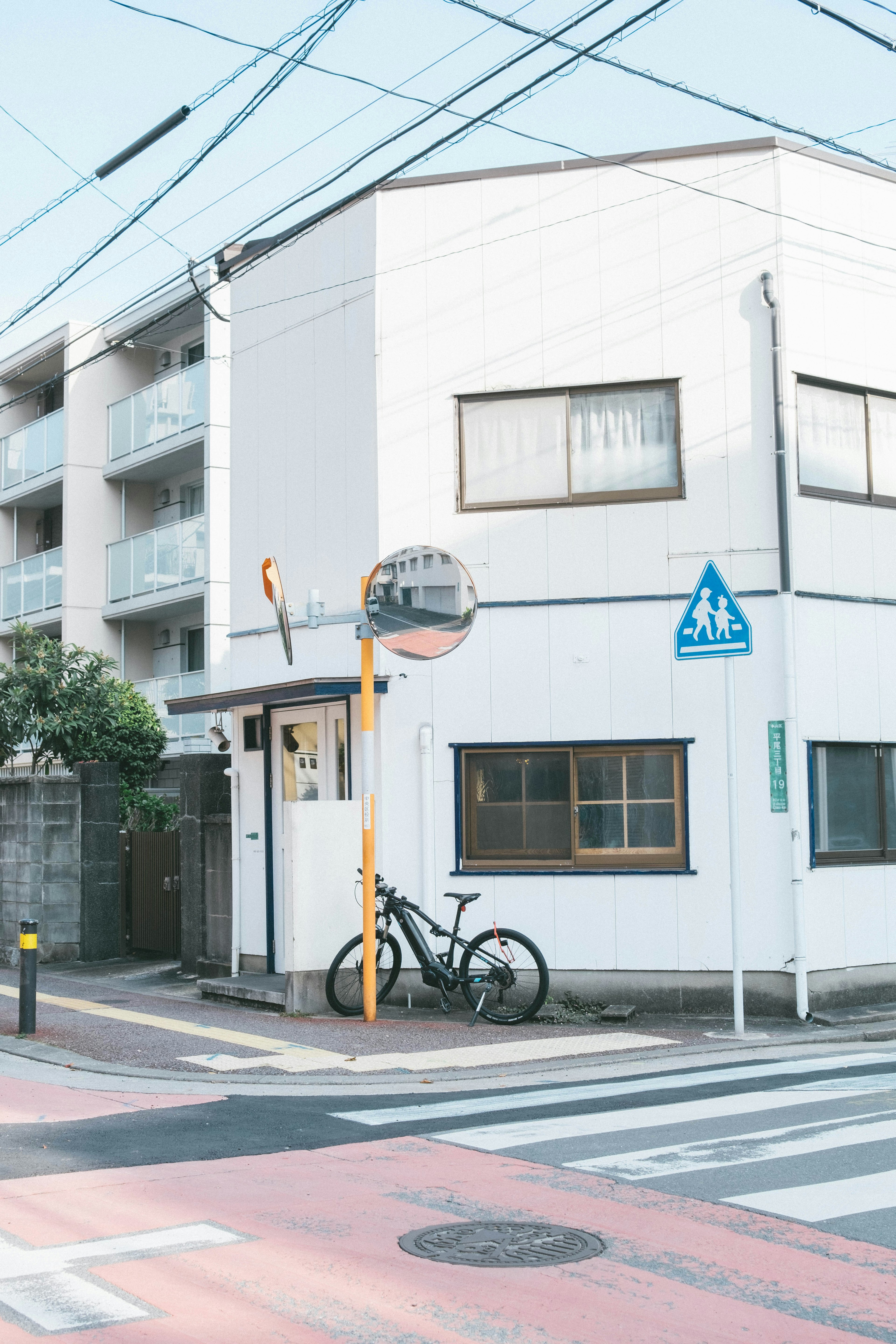 白い家と自転車がある交差点の風景