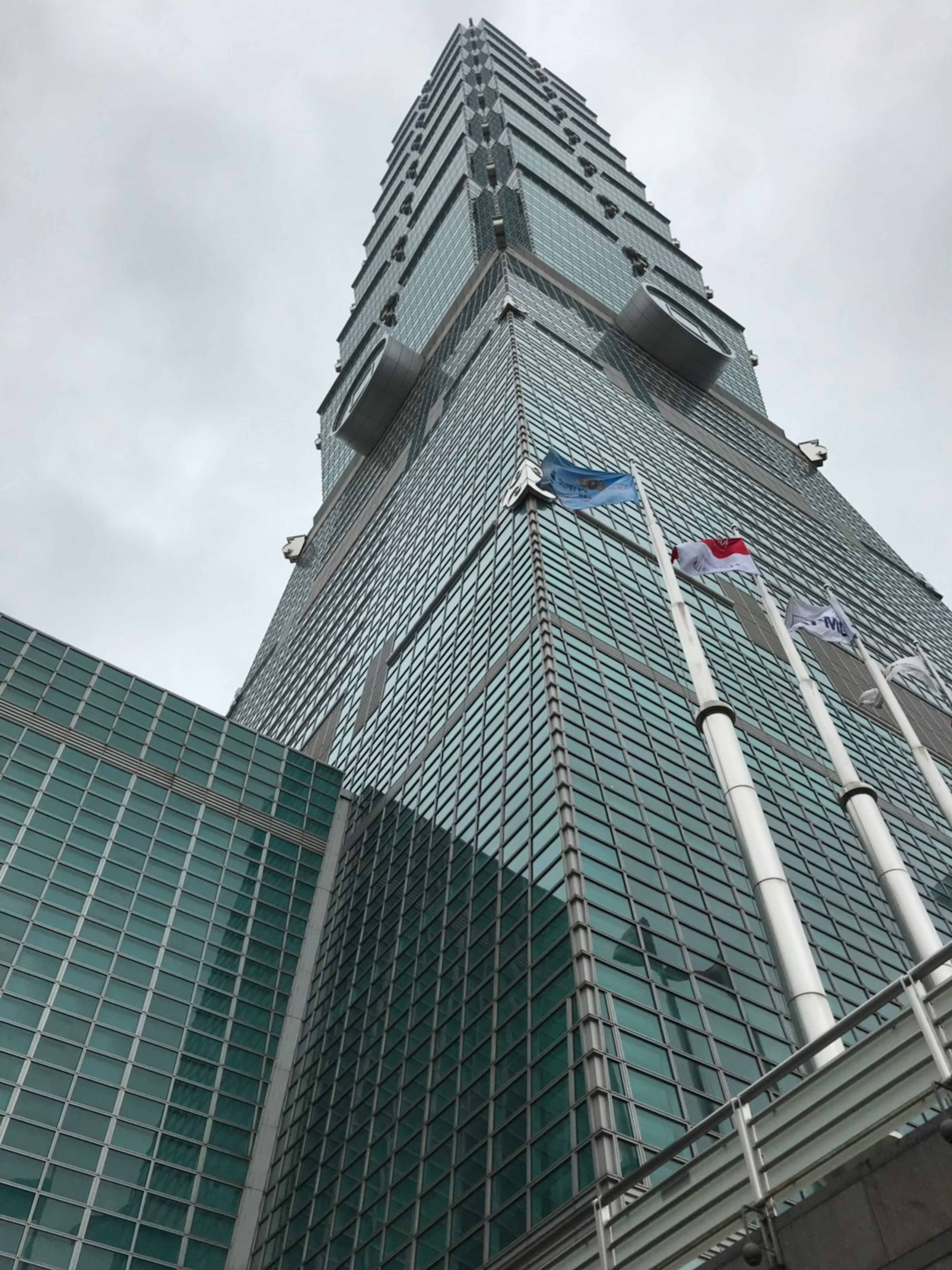 Sebuah gedung pencakar langit dilihat dari bawah di bawah langit mendung