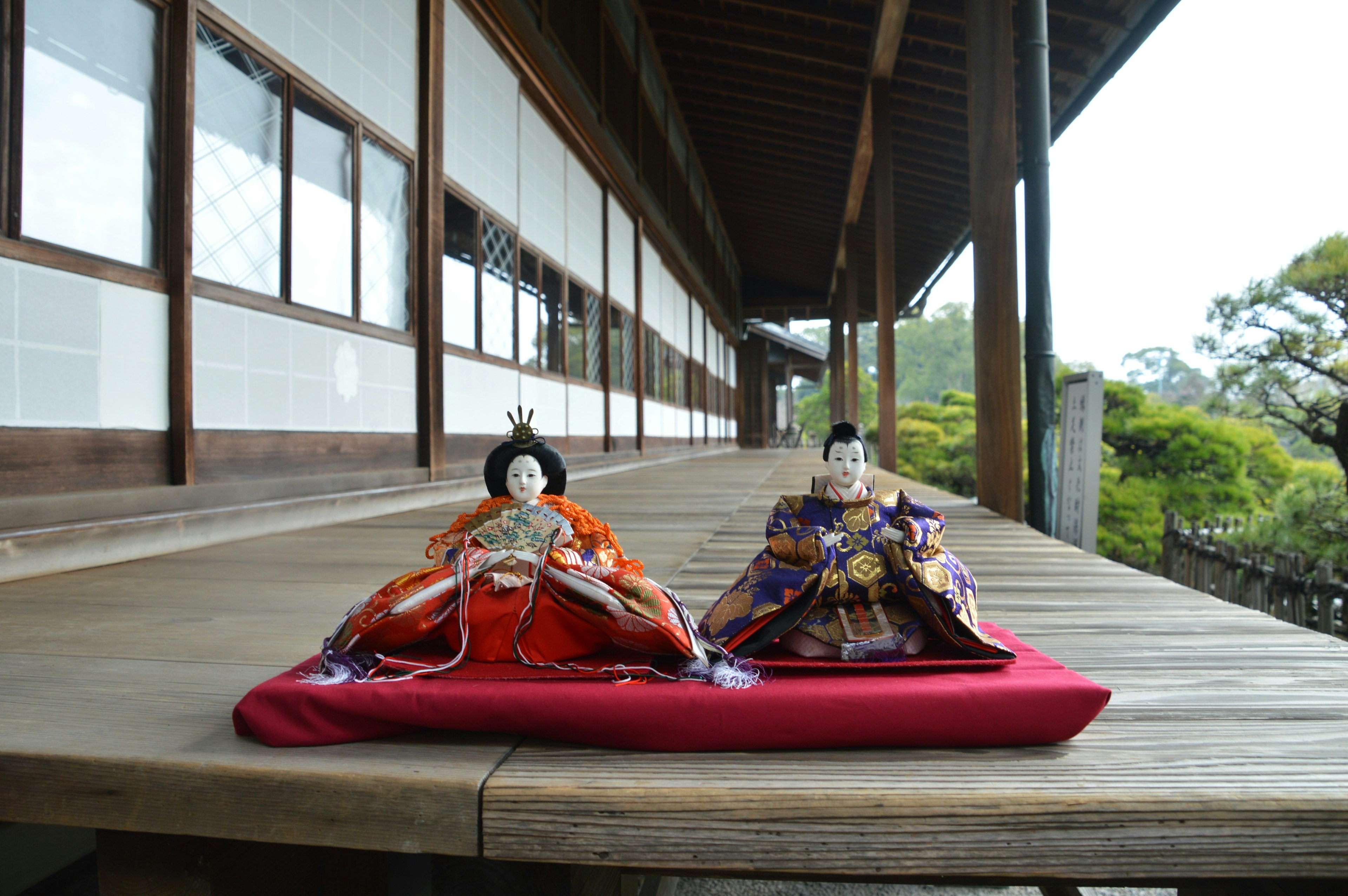 Traditional Japanese hina dolls displayed on a red cloth