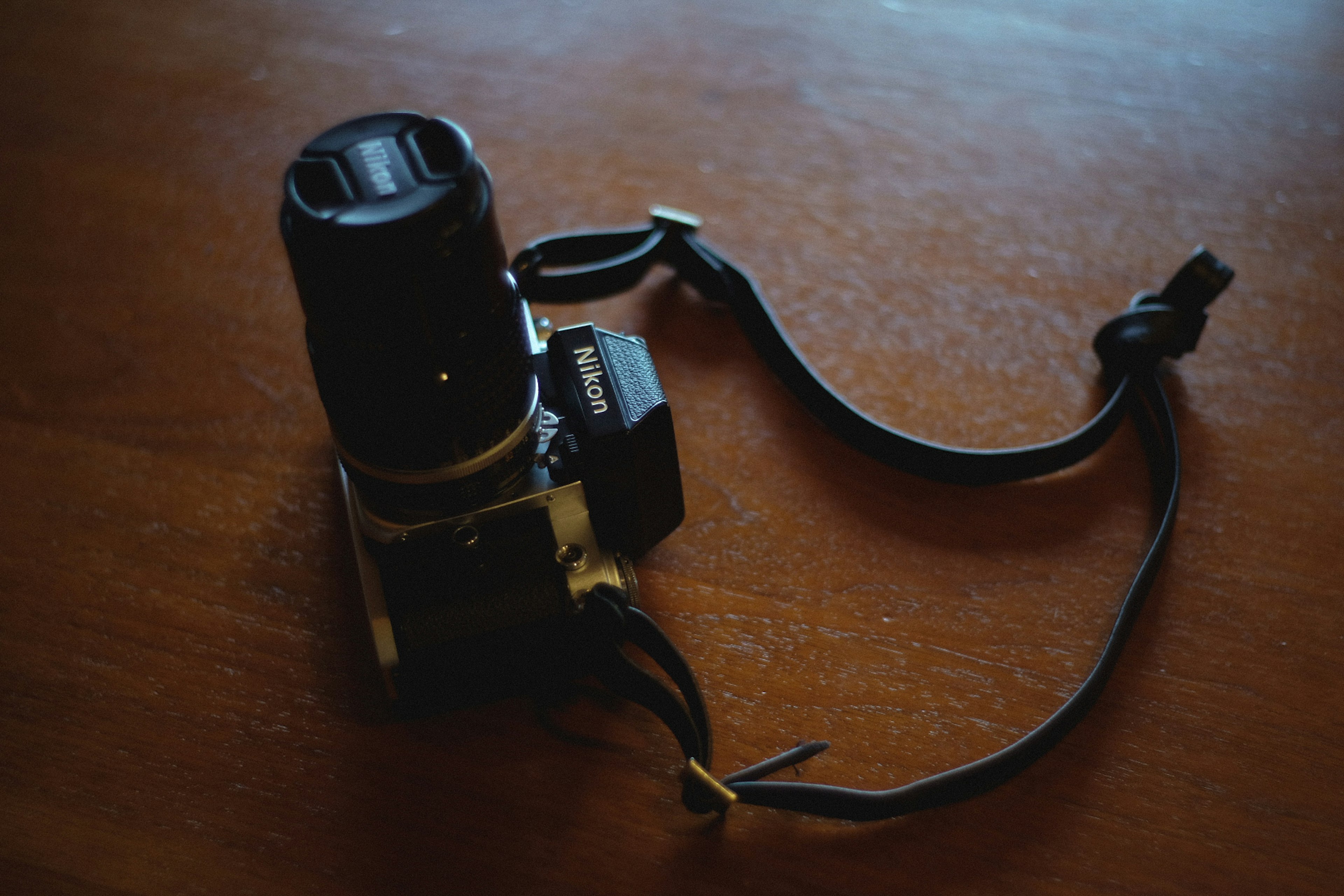 Camera with lens on a wooden table surface