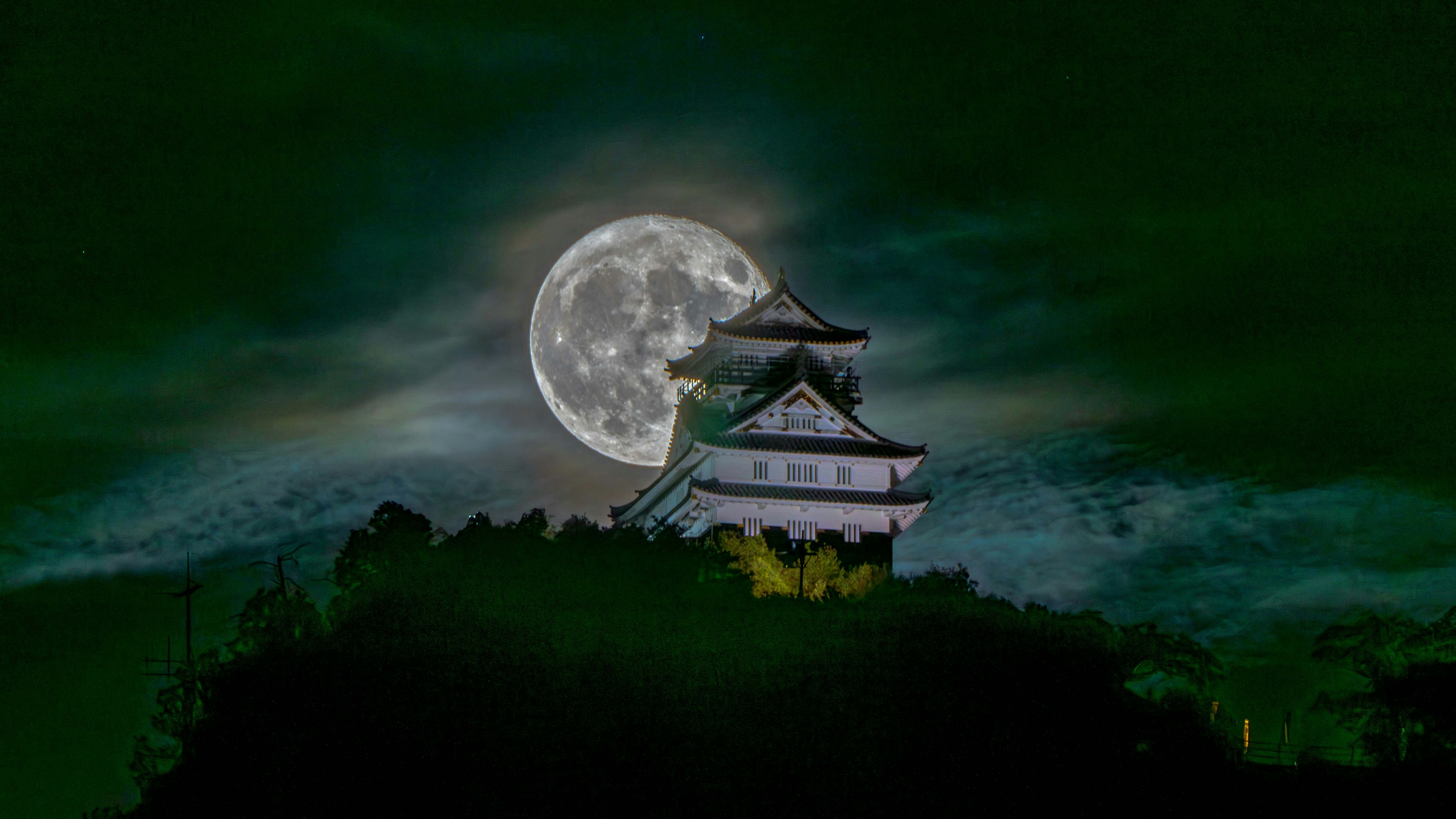 Silueta de un castillo contra una gran luna llena