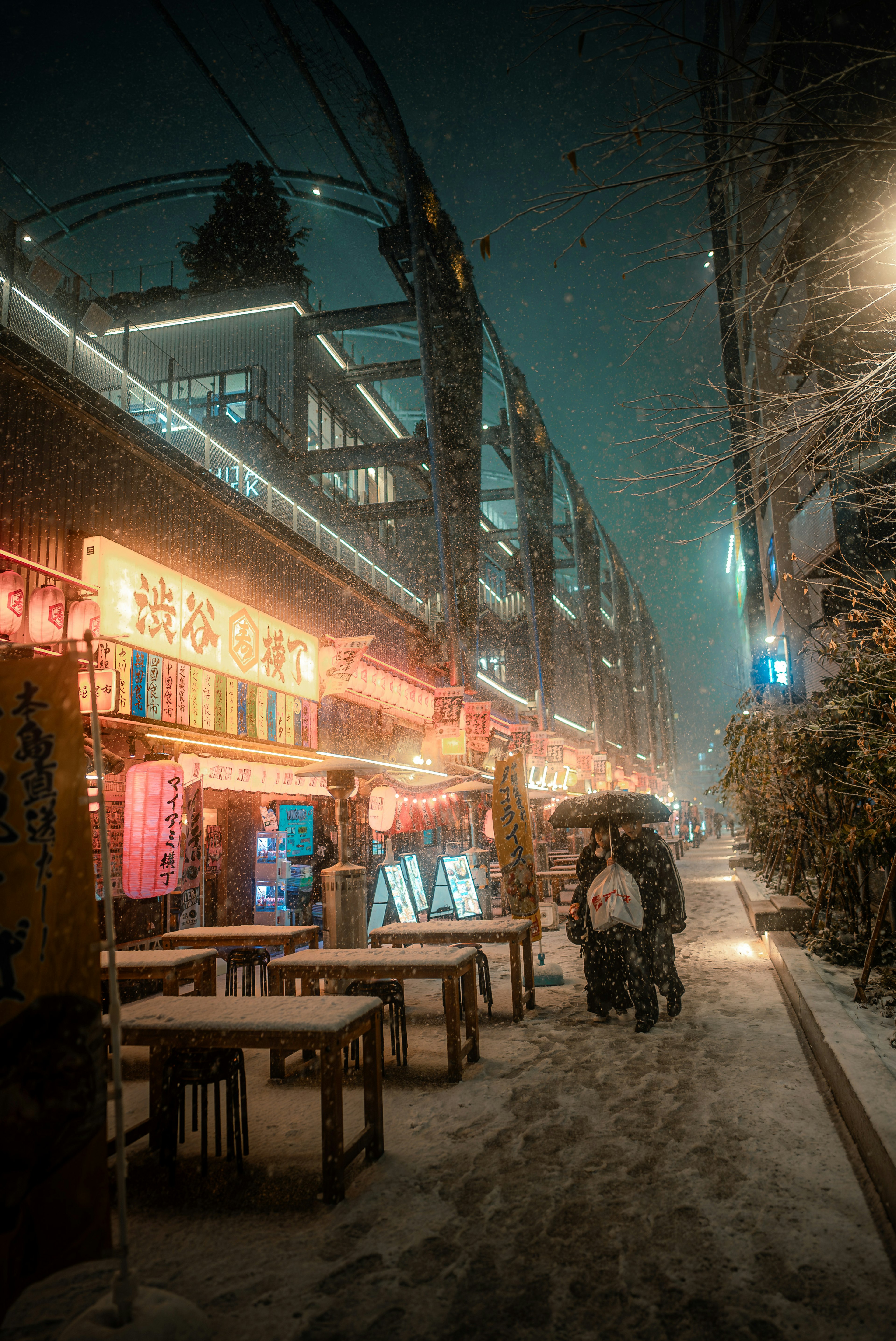 Winterliche Straßenszene mit leuchtenden Ständen und Menschen im Schnee