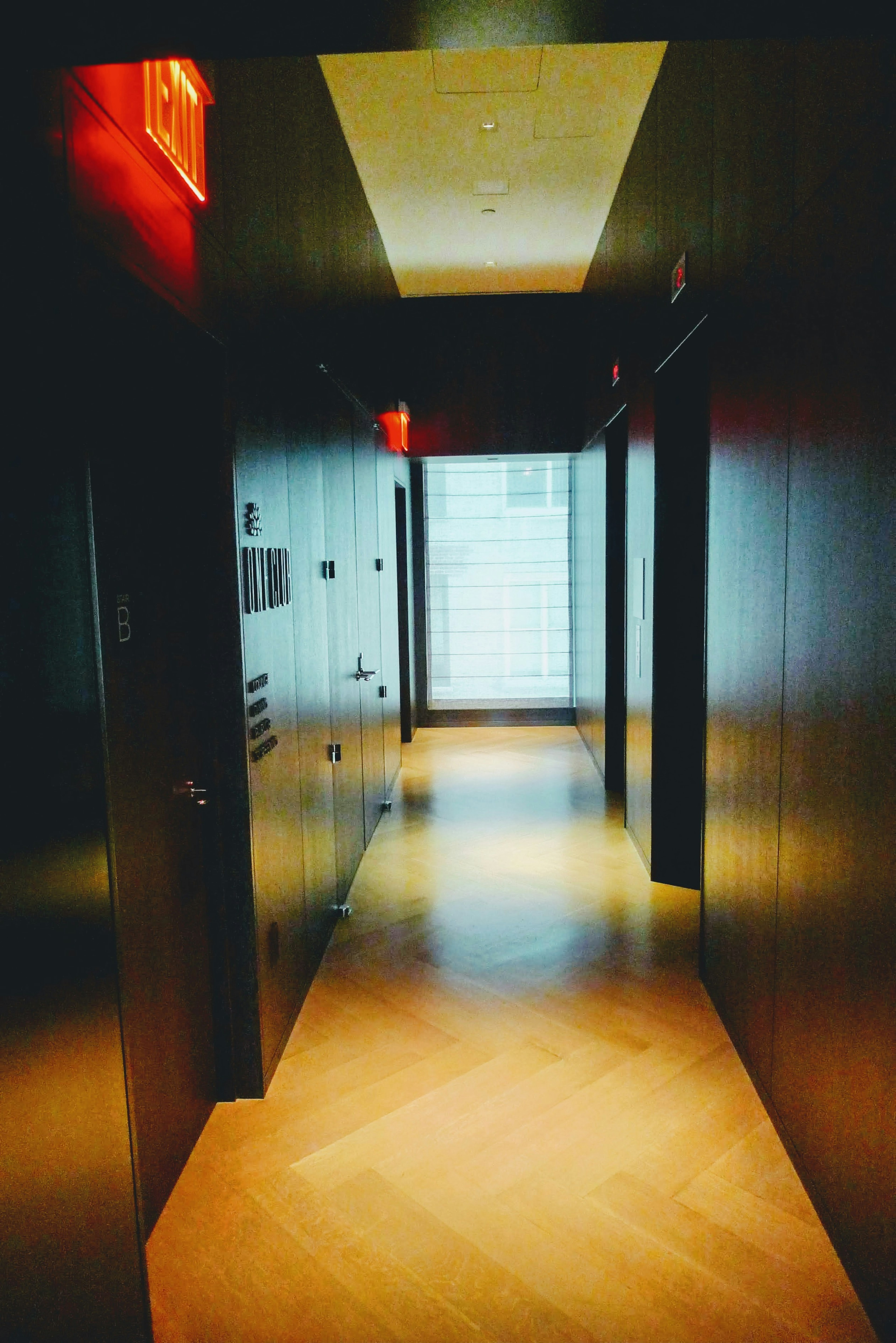 Interior photo of a modern hallway featuring bright window and dark wall design