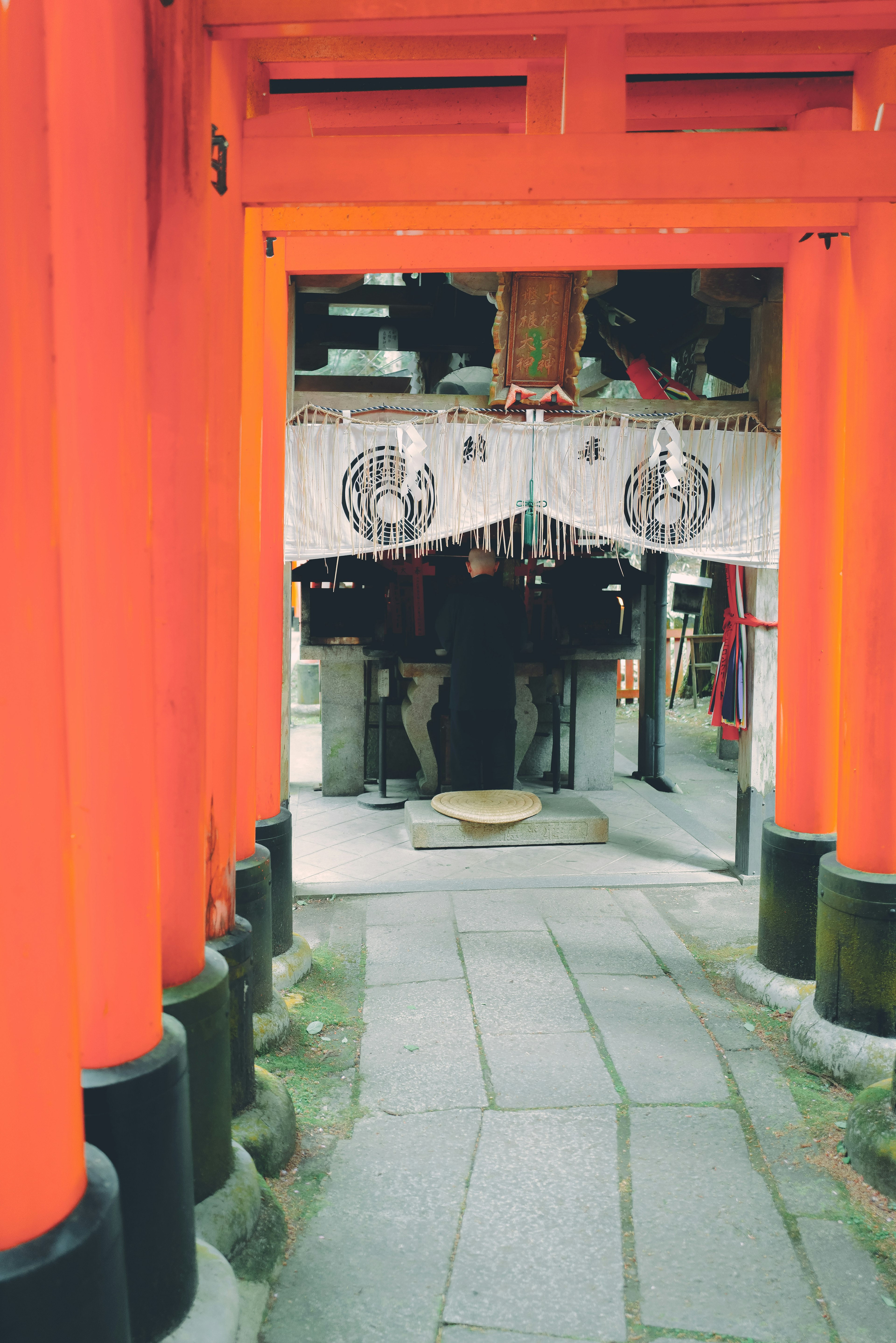 Allée menant à l'entrée d'un sanctuaire à travers des torii orange