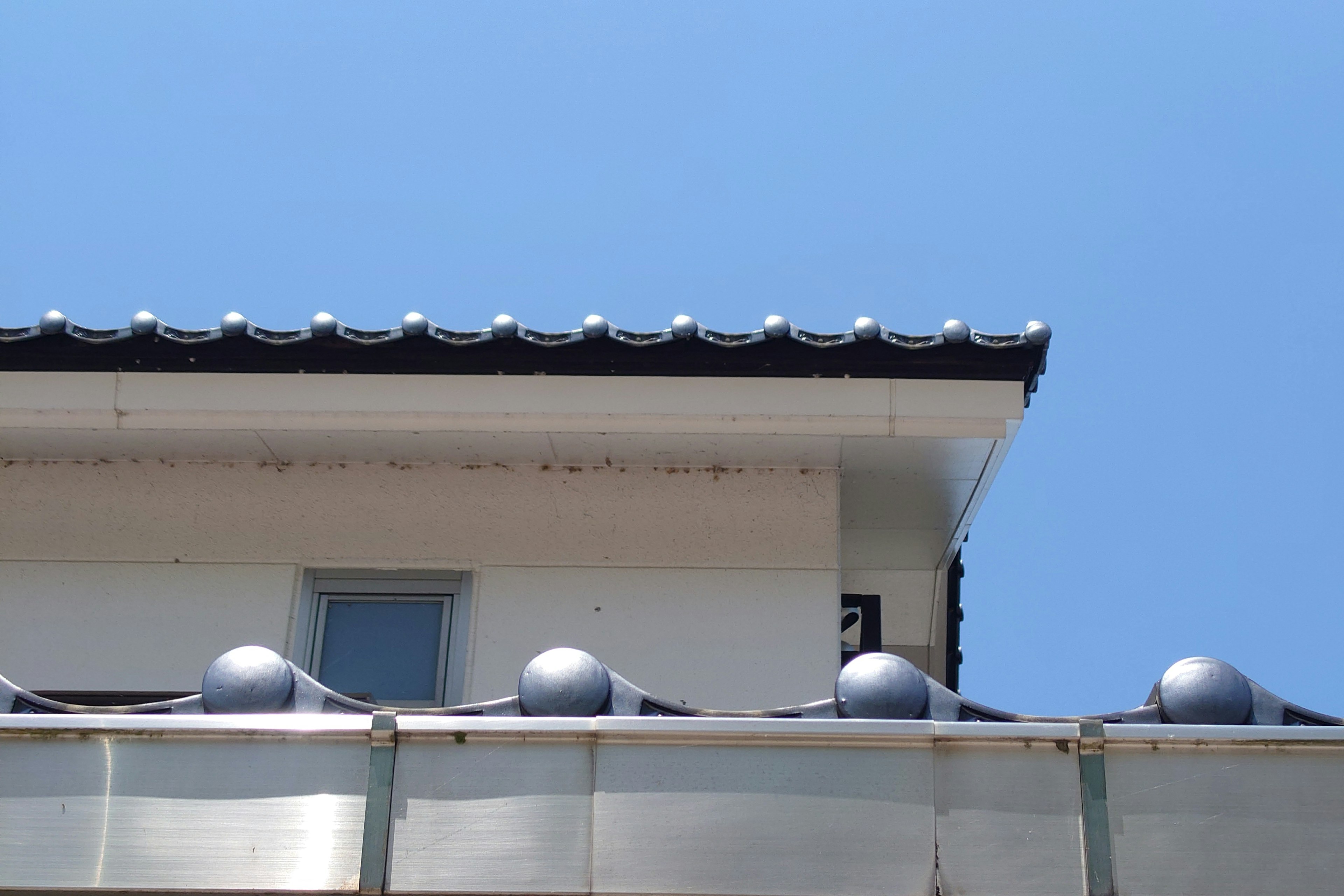 Vue supérieure d'un toit de bâtiment avec une fenêtre sous un ciel bleu