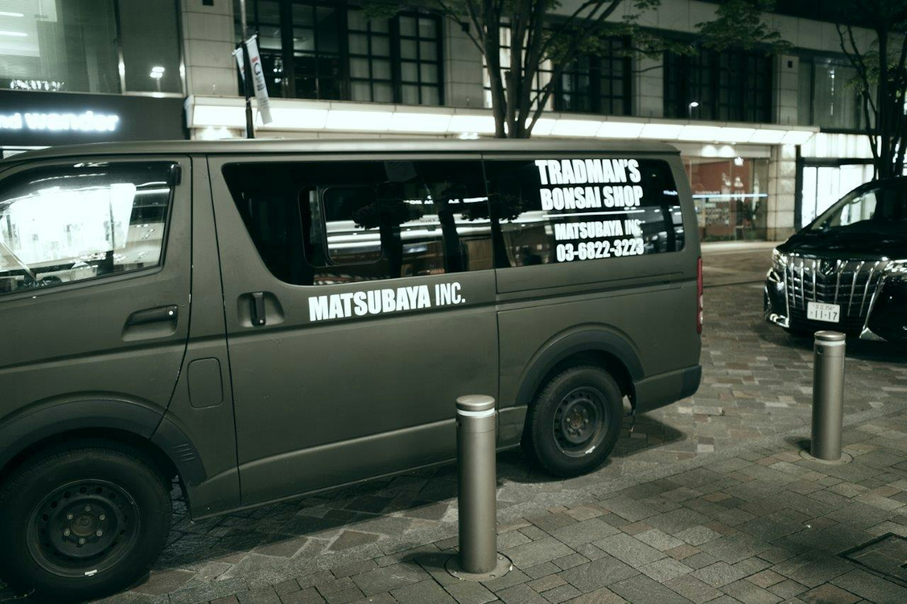 Un minivan parcheggiato in città di notte con pubblicità di servizio taxi