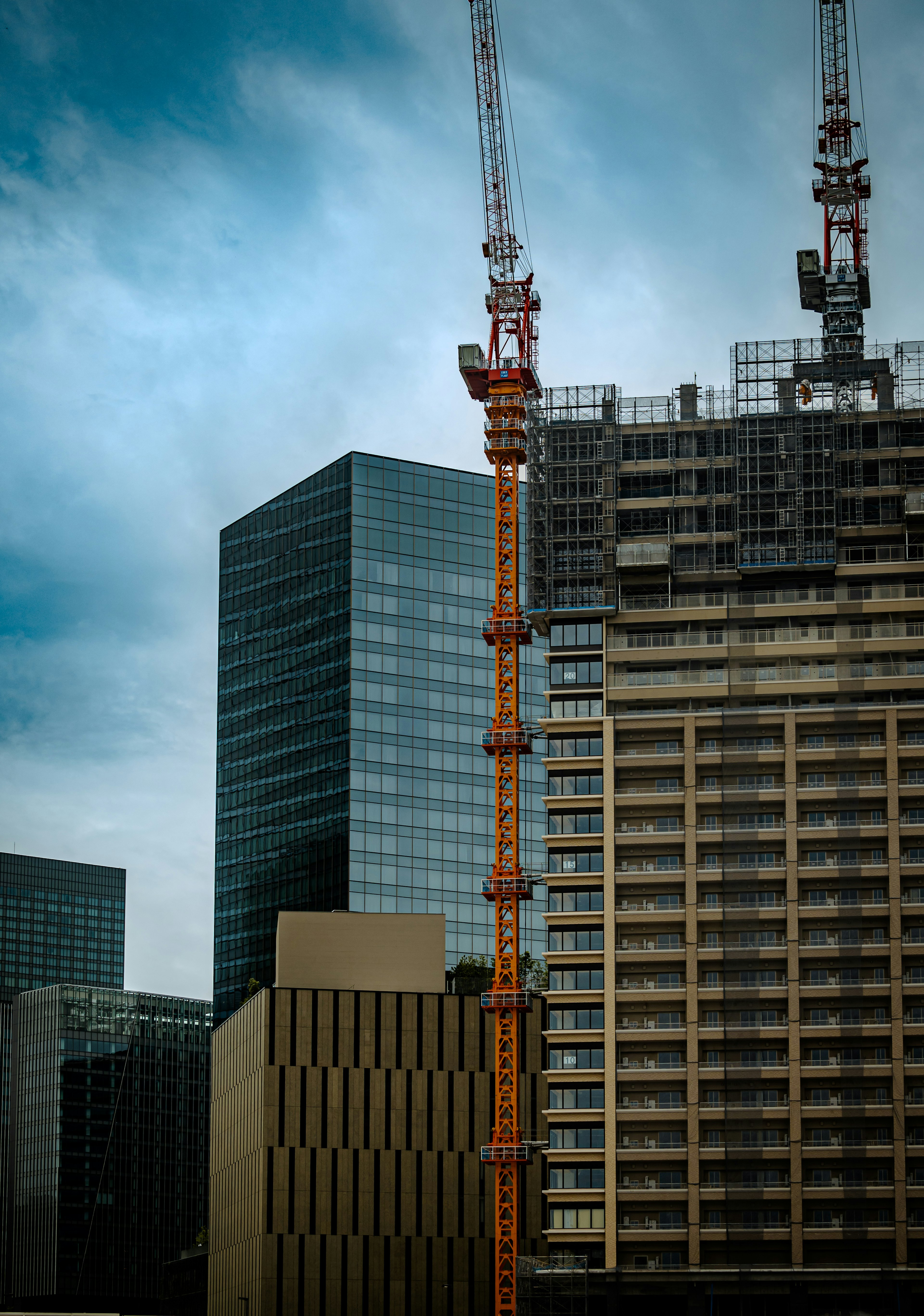 Paisaje urbano con un sitio de construcción de edificios altos y grúas