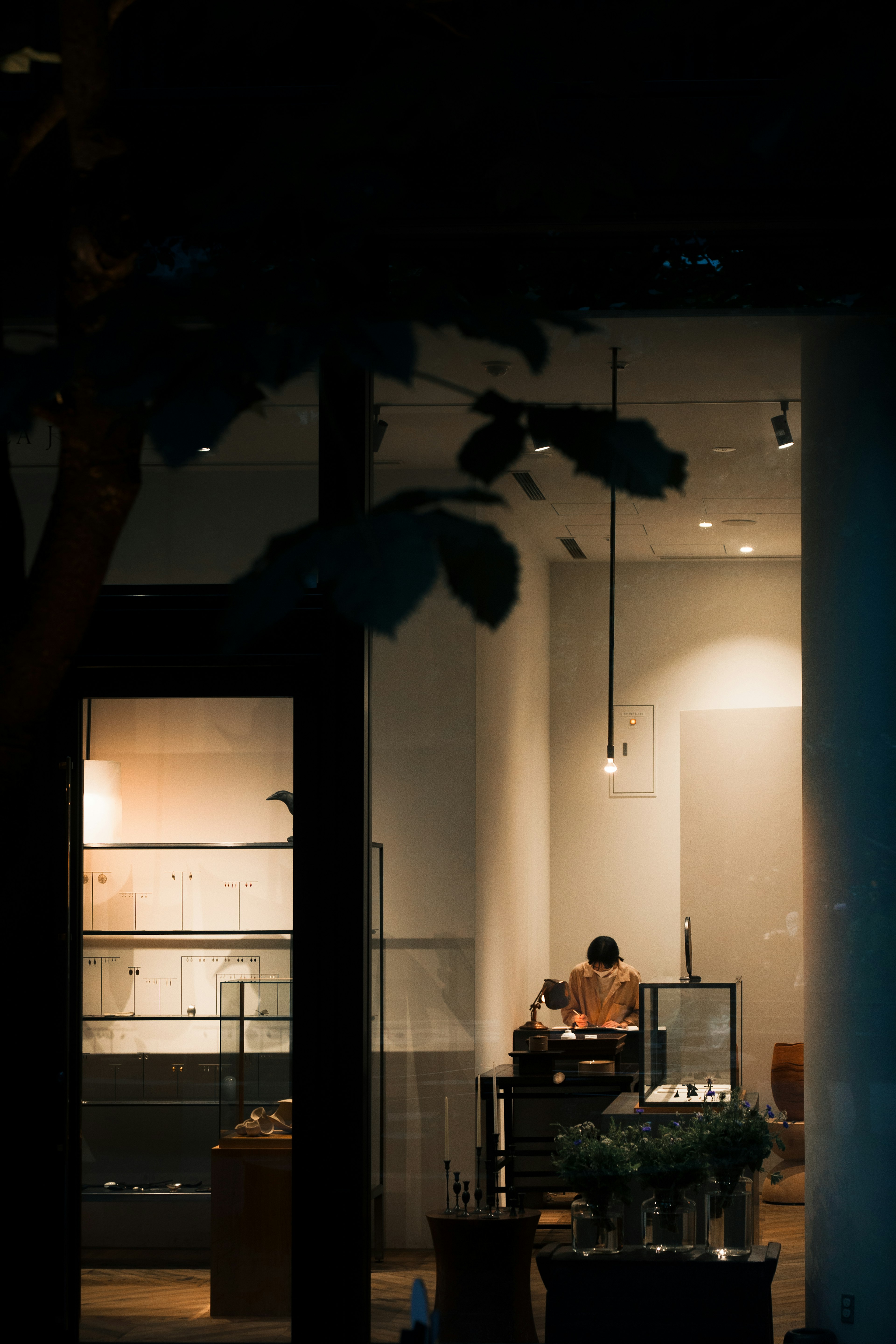 Image montrant l'intérieur d'un magasin la nuit Éclairage doux avec des produits exposés Un travailleur est visible