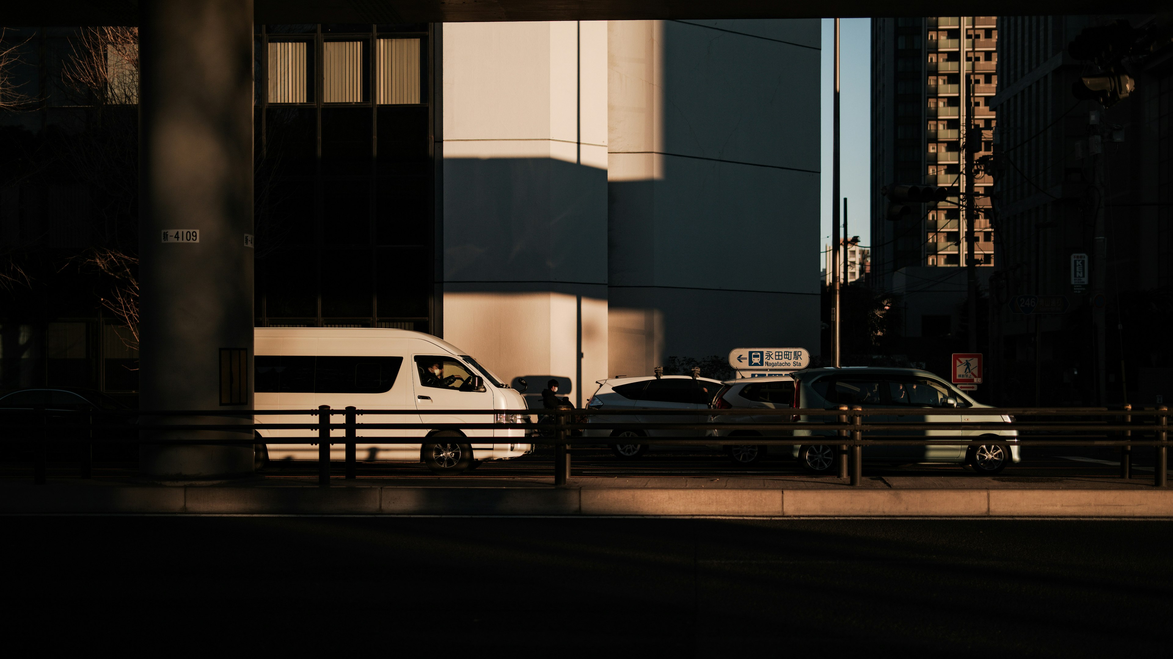 Städtische Szene mit geparkten Fahrzeugen und kontrastierenden Schatten