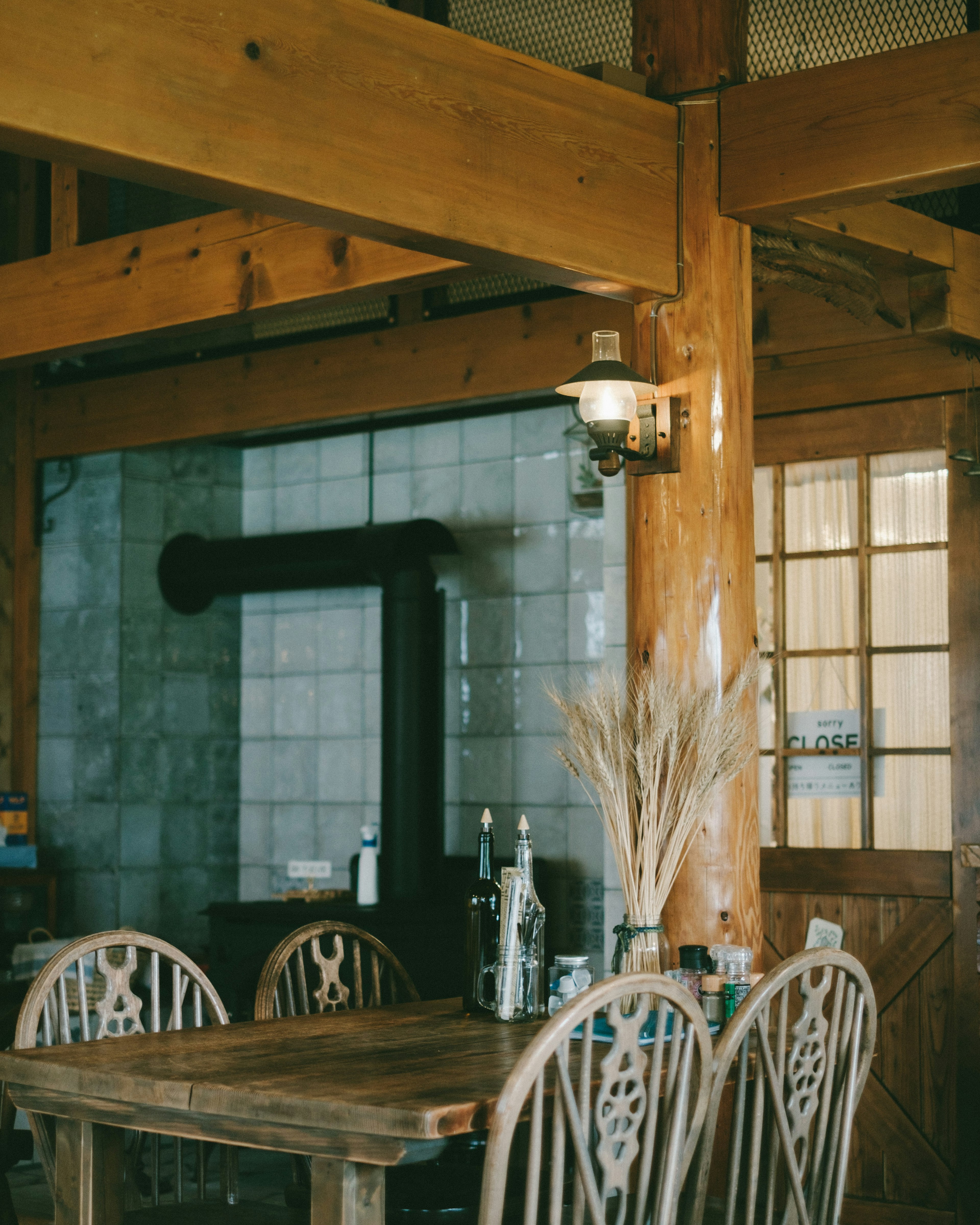 Interior scene of a cafe with wooden table and chairs featuring decorative plants and light fixtures