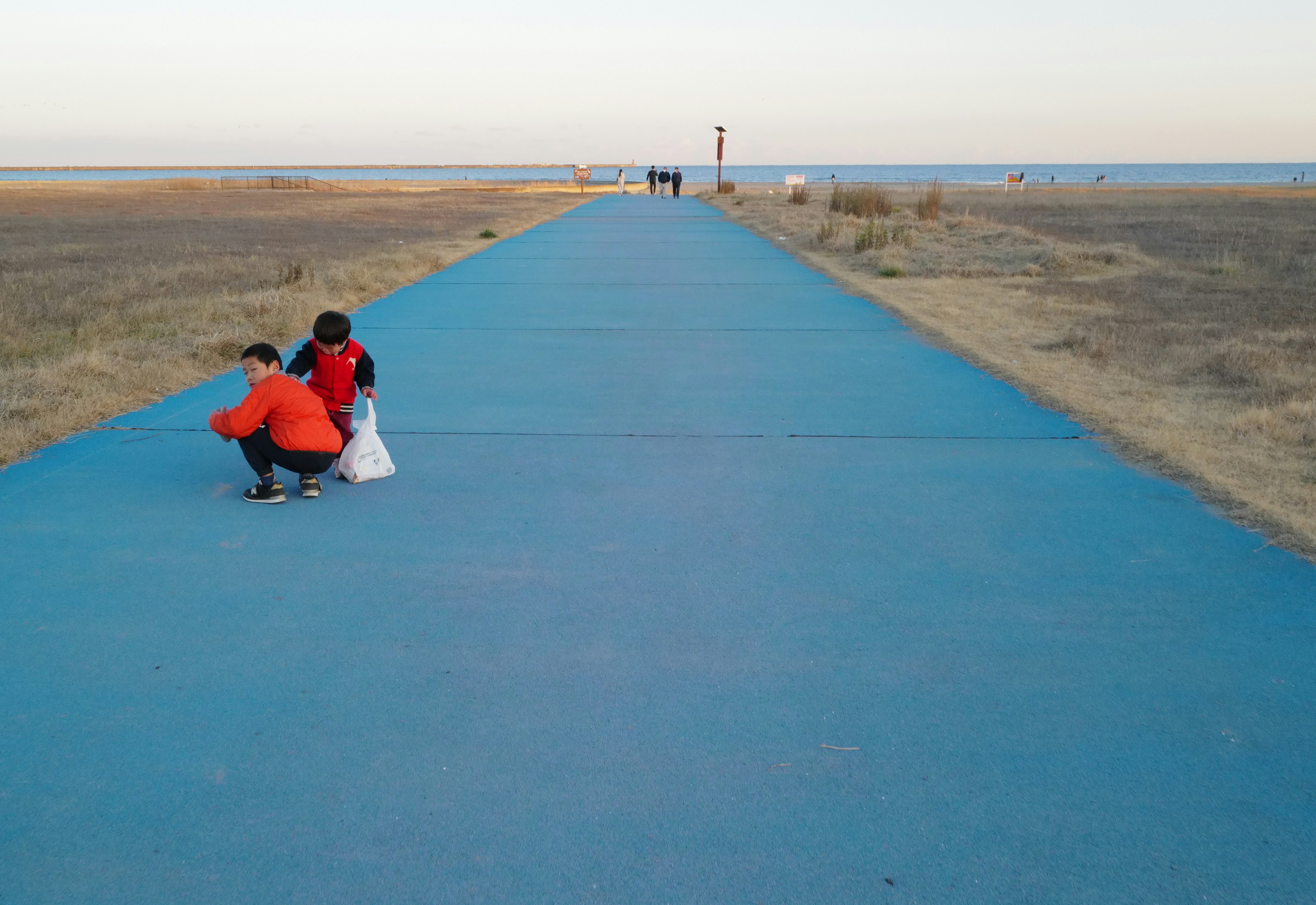 Silueta de niños en un camino azul