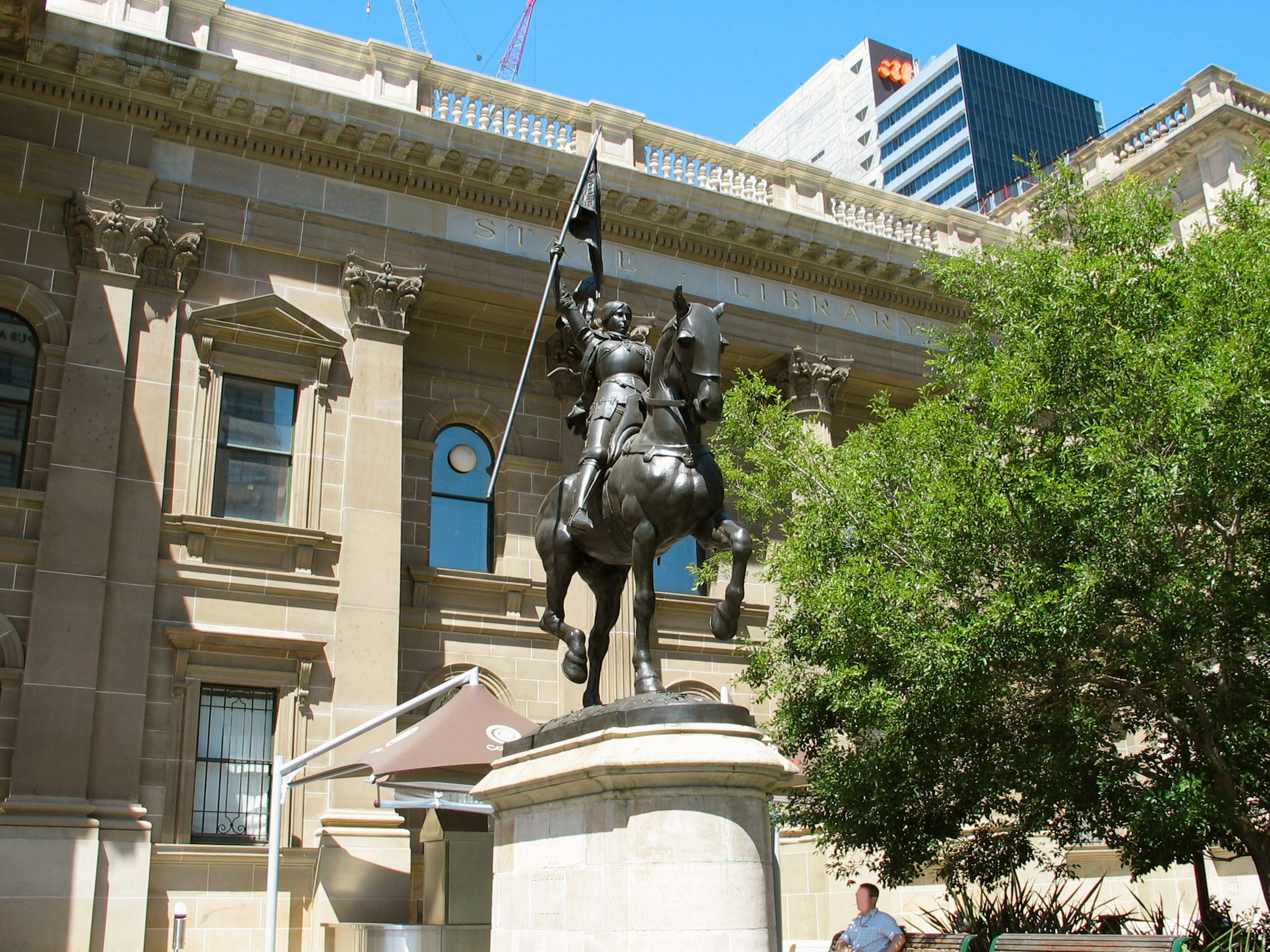 Statue en bronze d'un chevalier à cheval devant un bâtiment historique