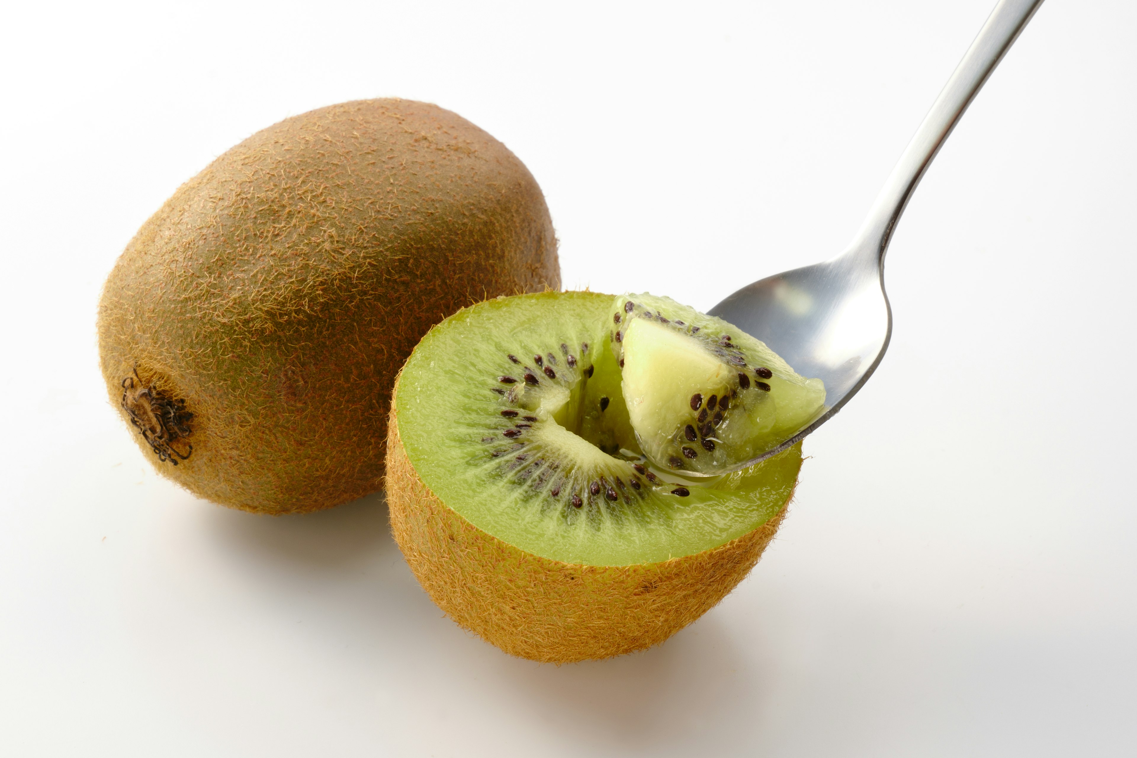 Mitad de un kiwi con una cuchara al lado