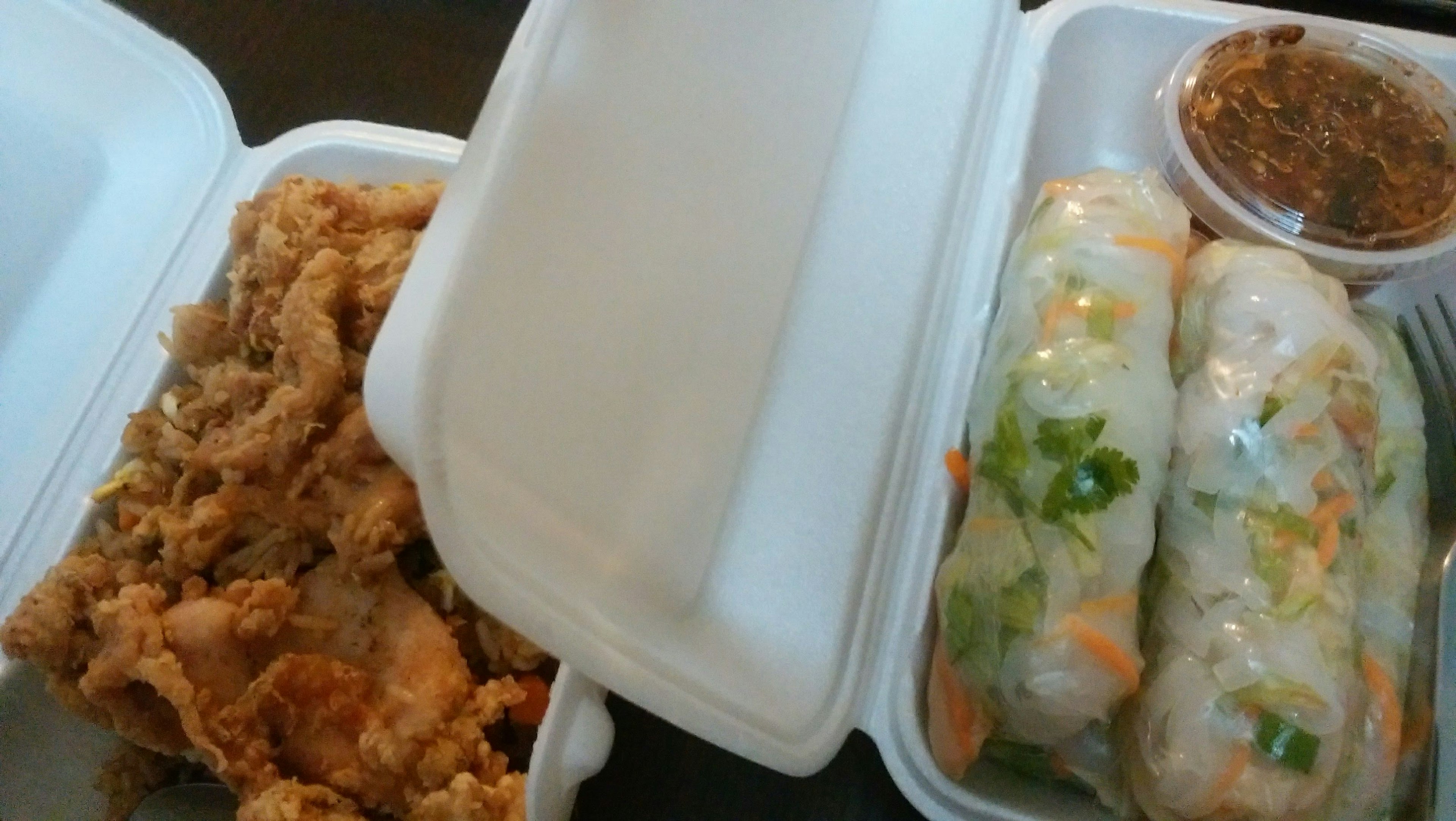 Takeout container with fried chicken and spring rolls