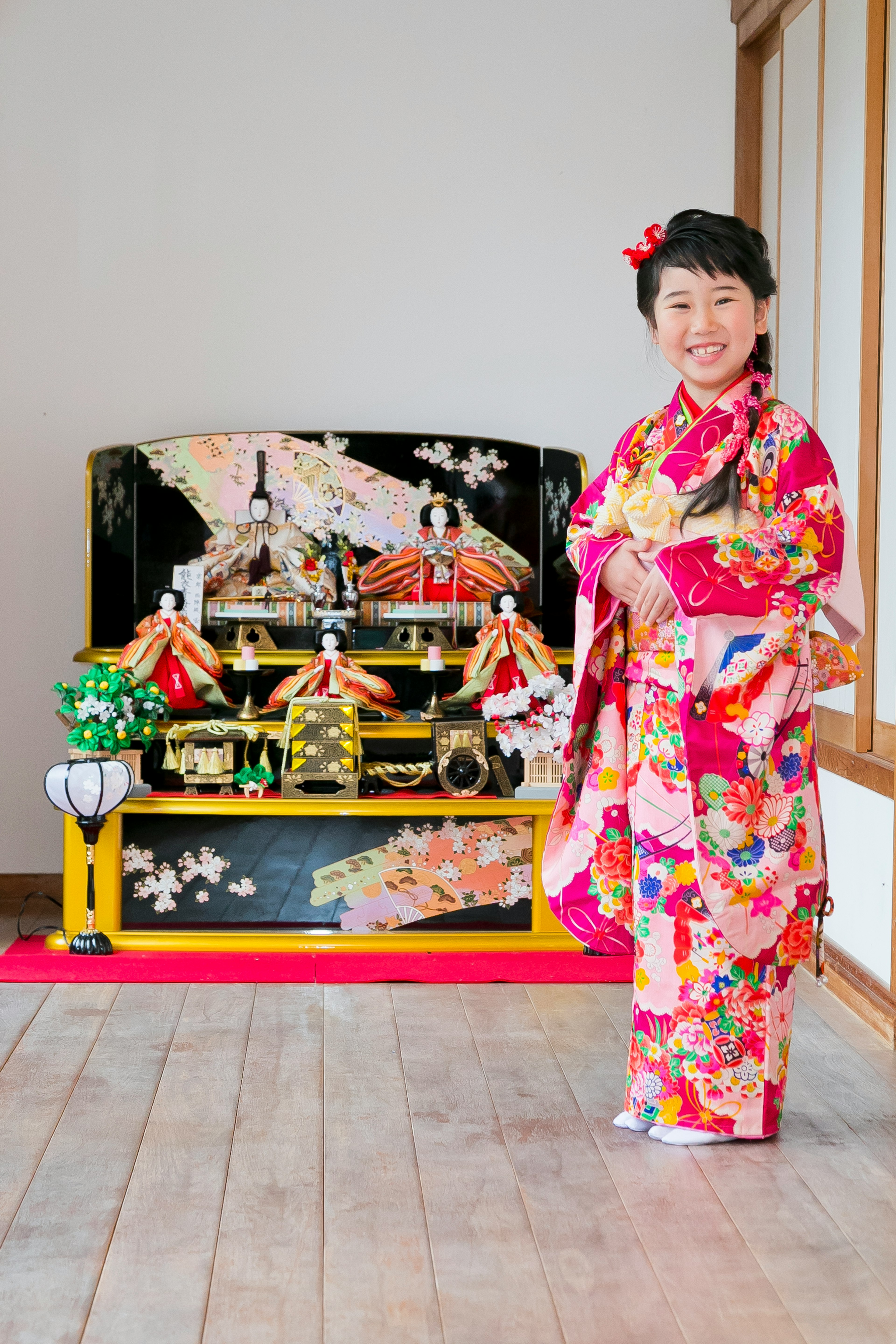 Femme en kimono traditionnel devant des poupées hina