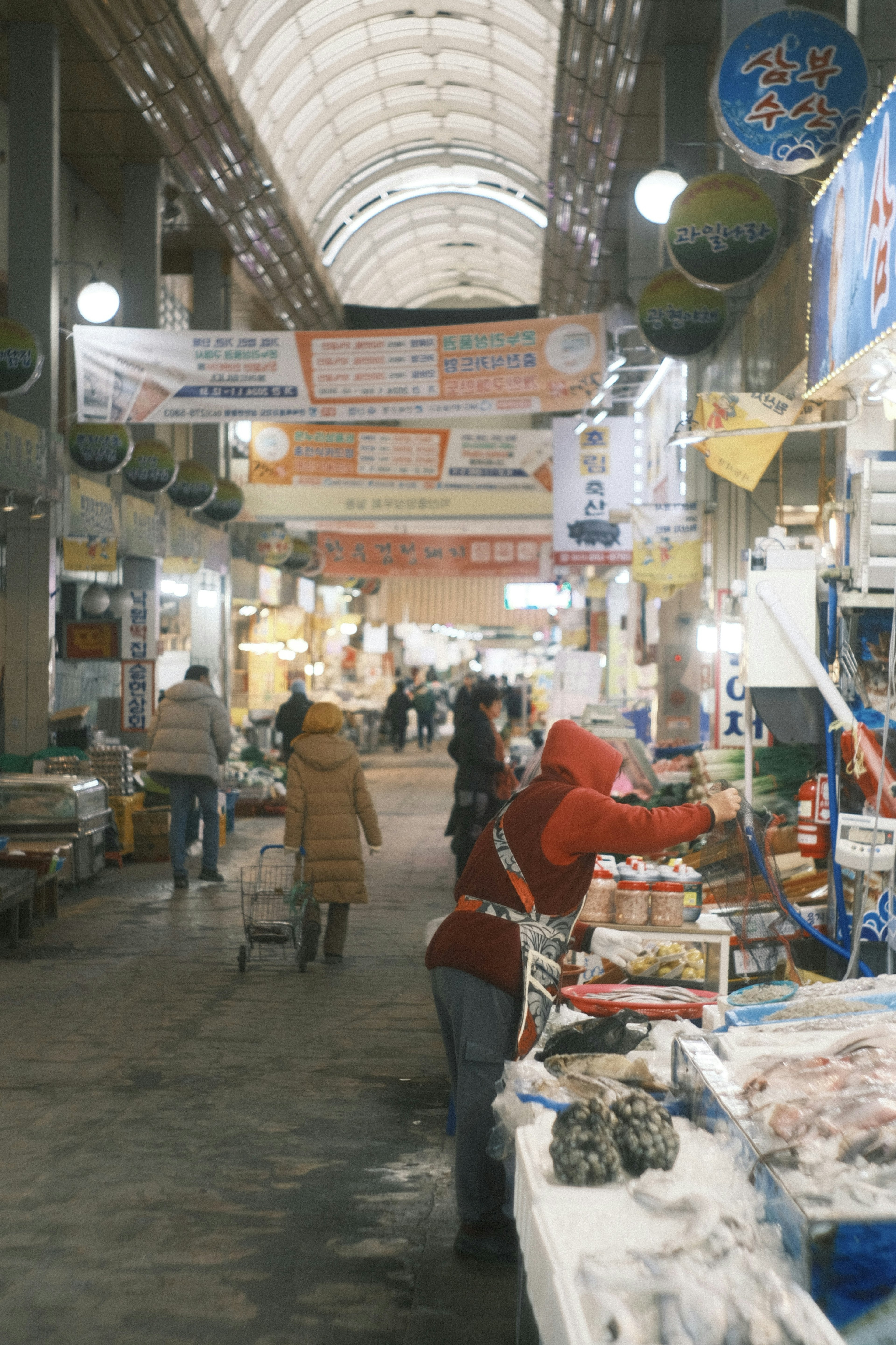 Une femme choisissant des produits dans une rue de marché animée