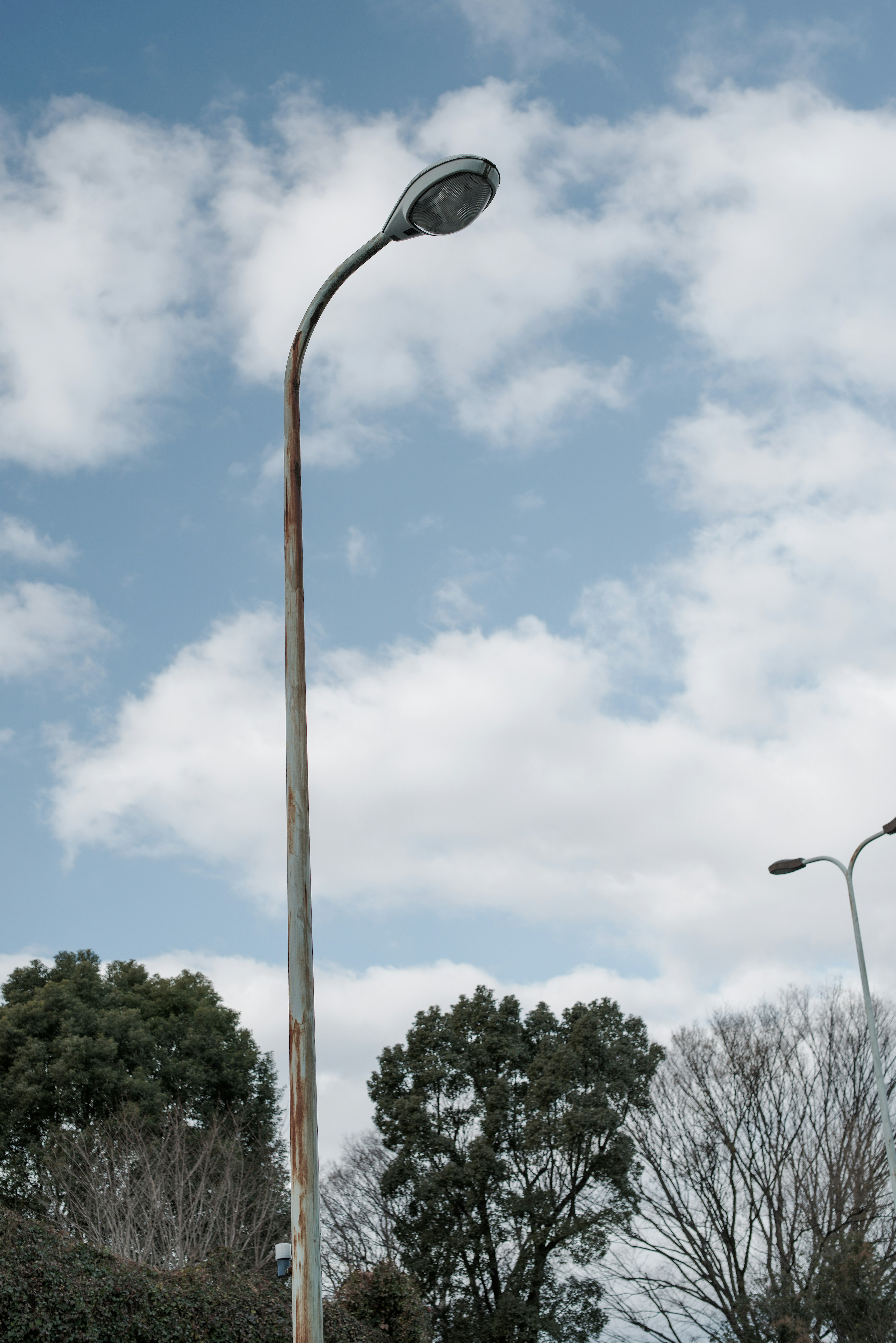 Streetlight standing under a blue sky with clouds