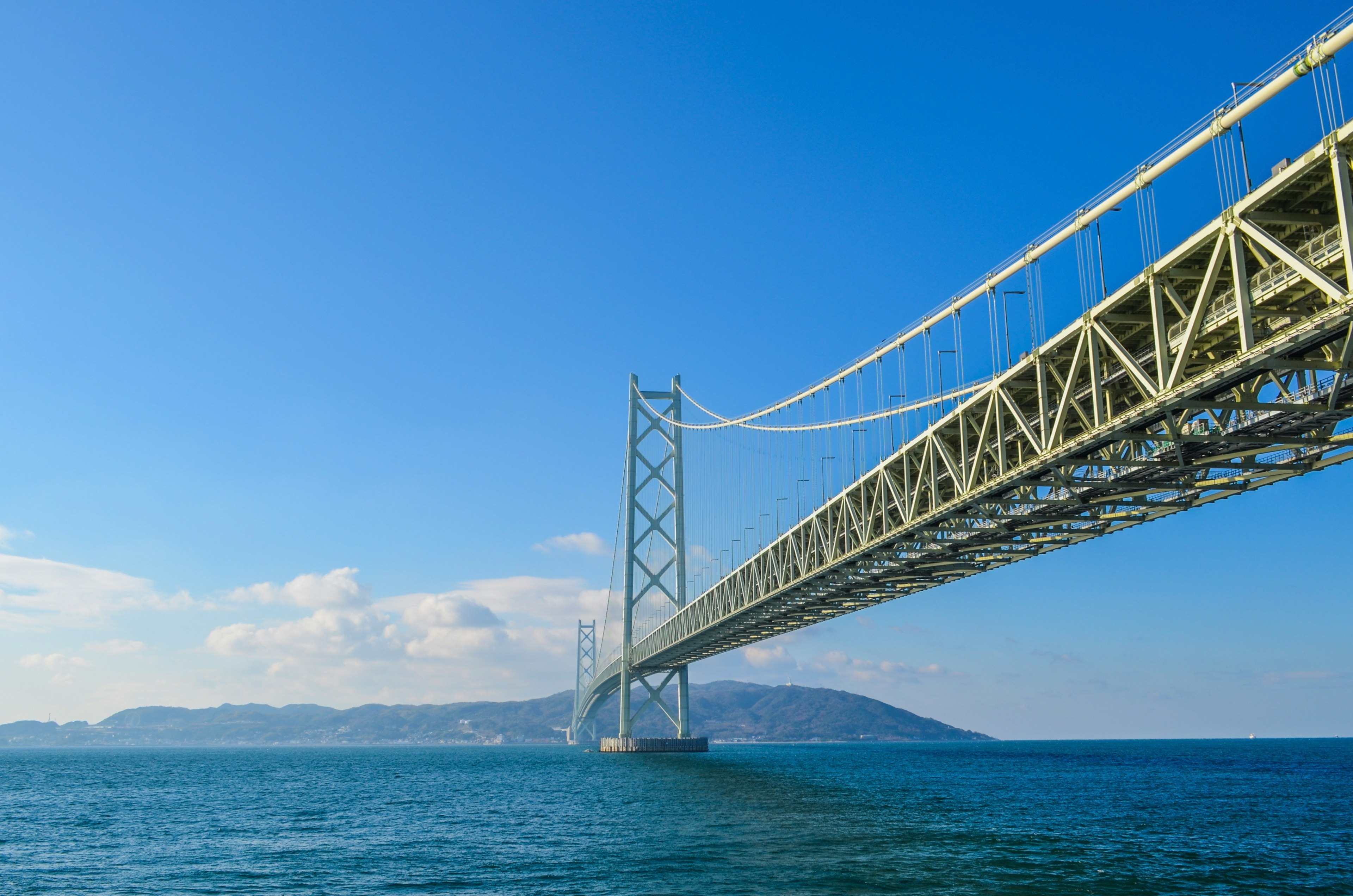 Jembatan Akashi Kaikyō dengan langit biru cerah dan lautan di bawah