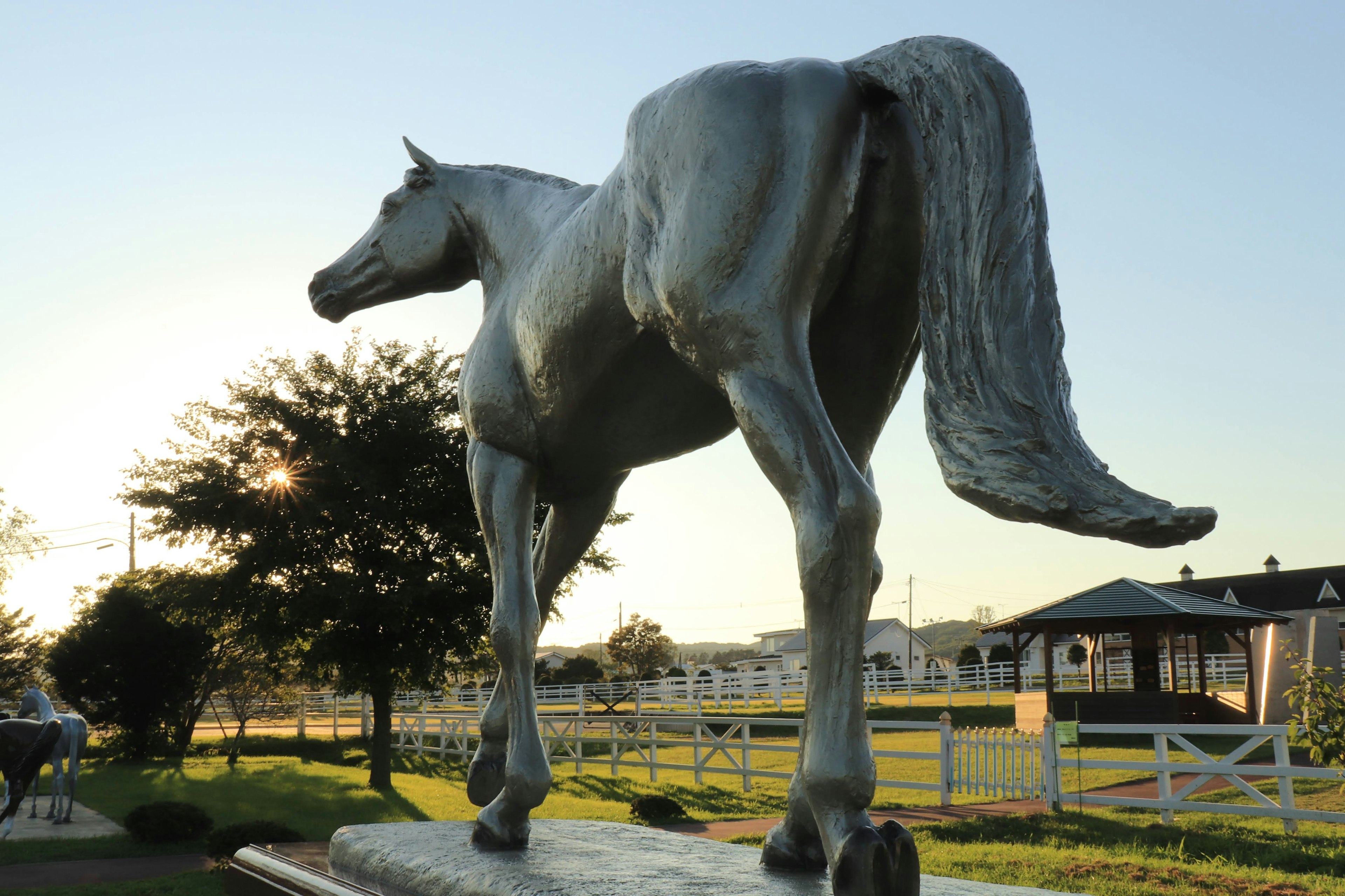 Una scultura di cavallo si erge con il tramonto sullo sfondo