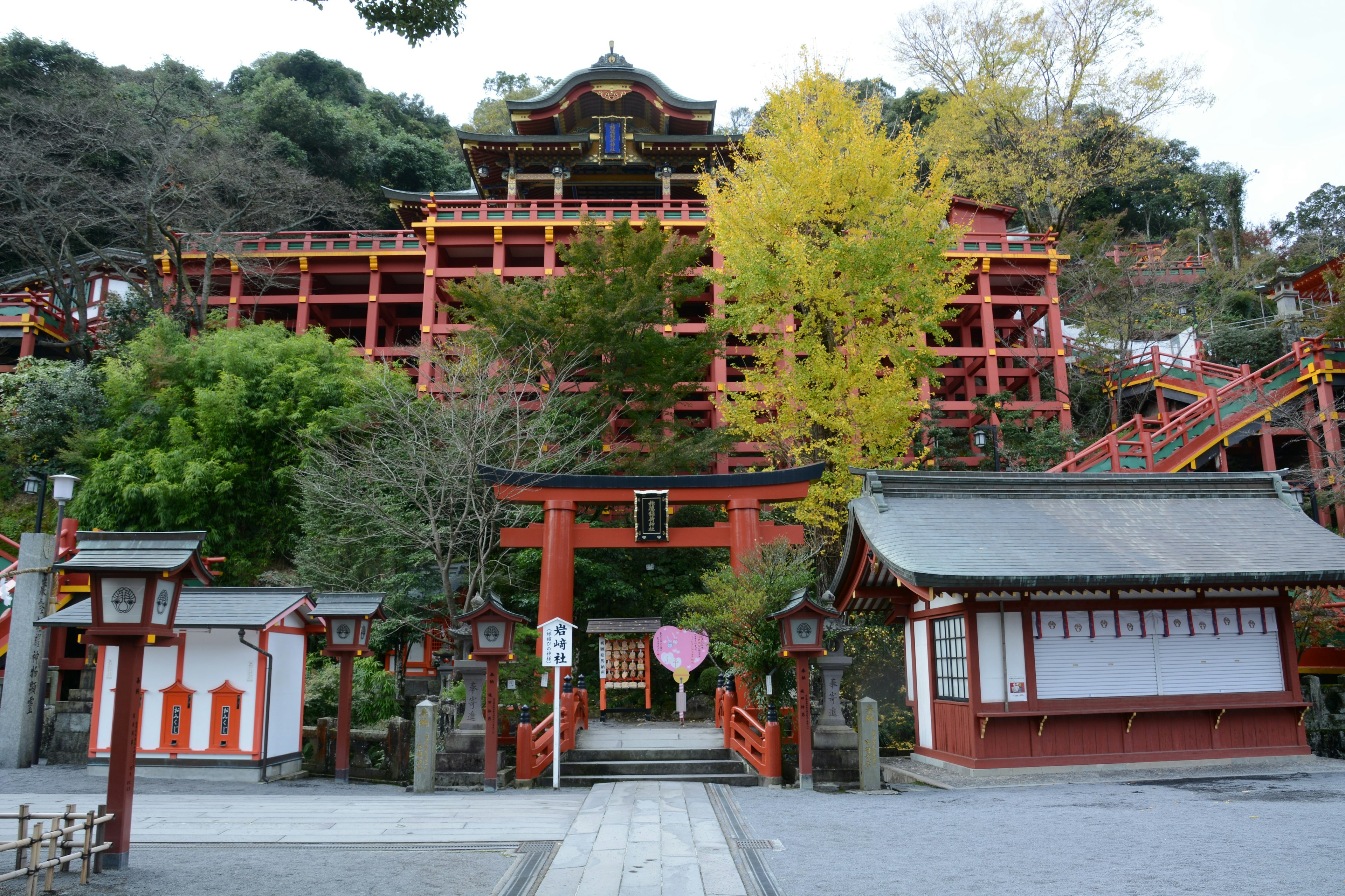 赤い建物と緑の木々がある寺院の景色