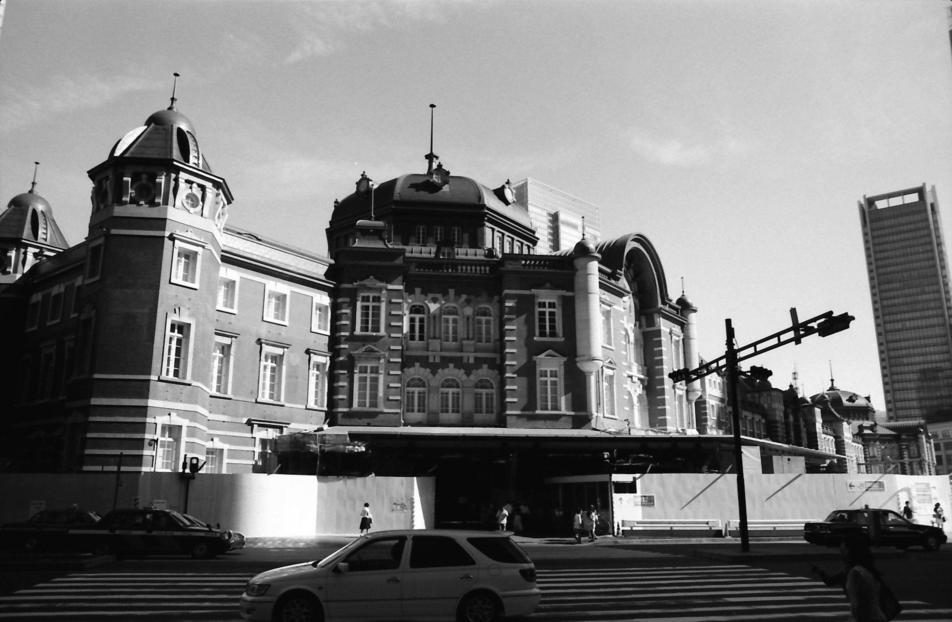 Edificio histórico de la estación de Tokio con un rascacielos moderno al fondo