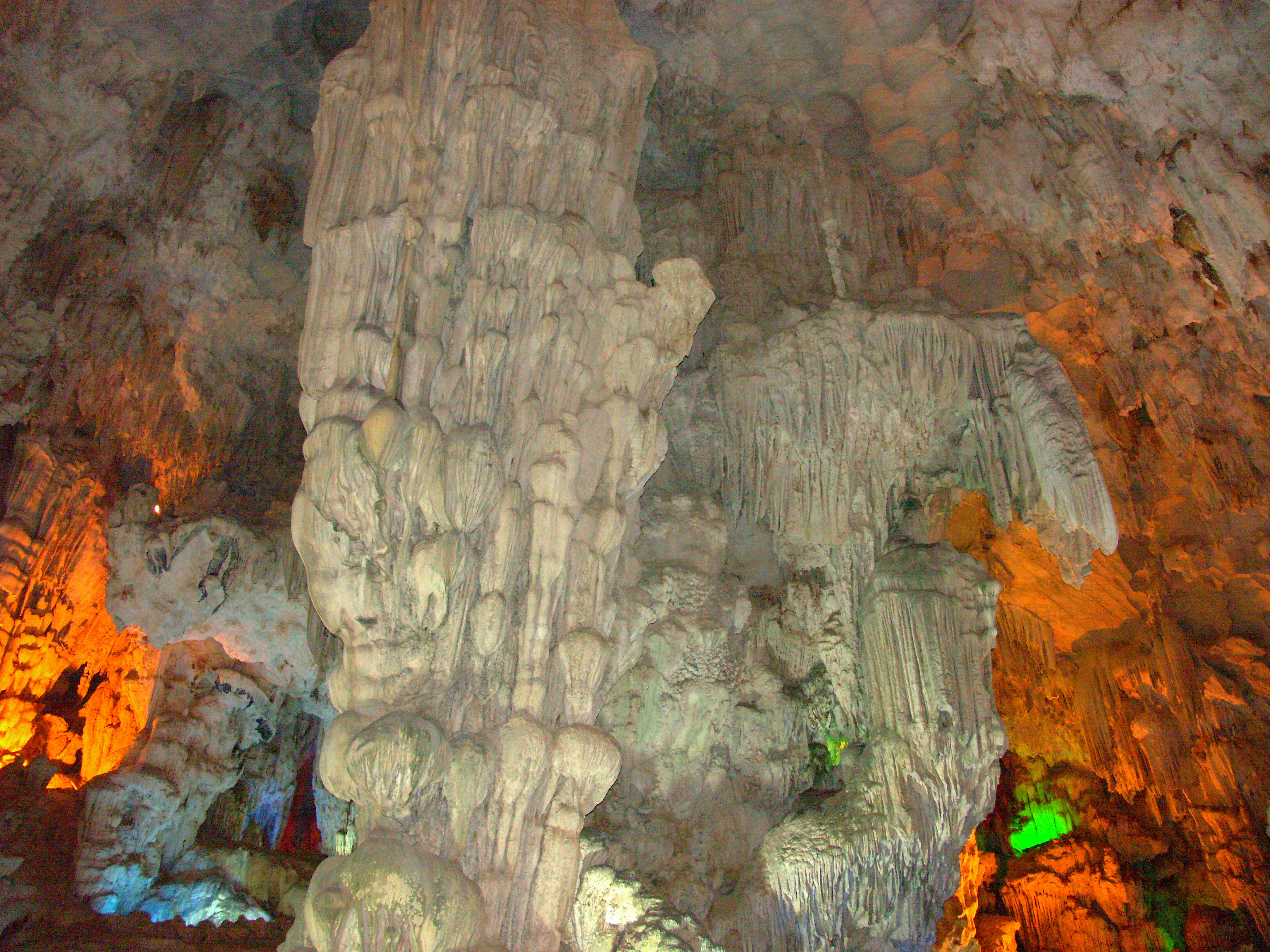 Grandi pilastri di pietra in una grotta con illuminazione colorata