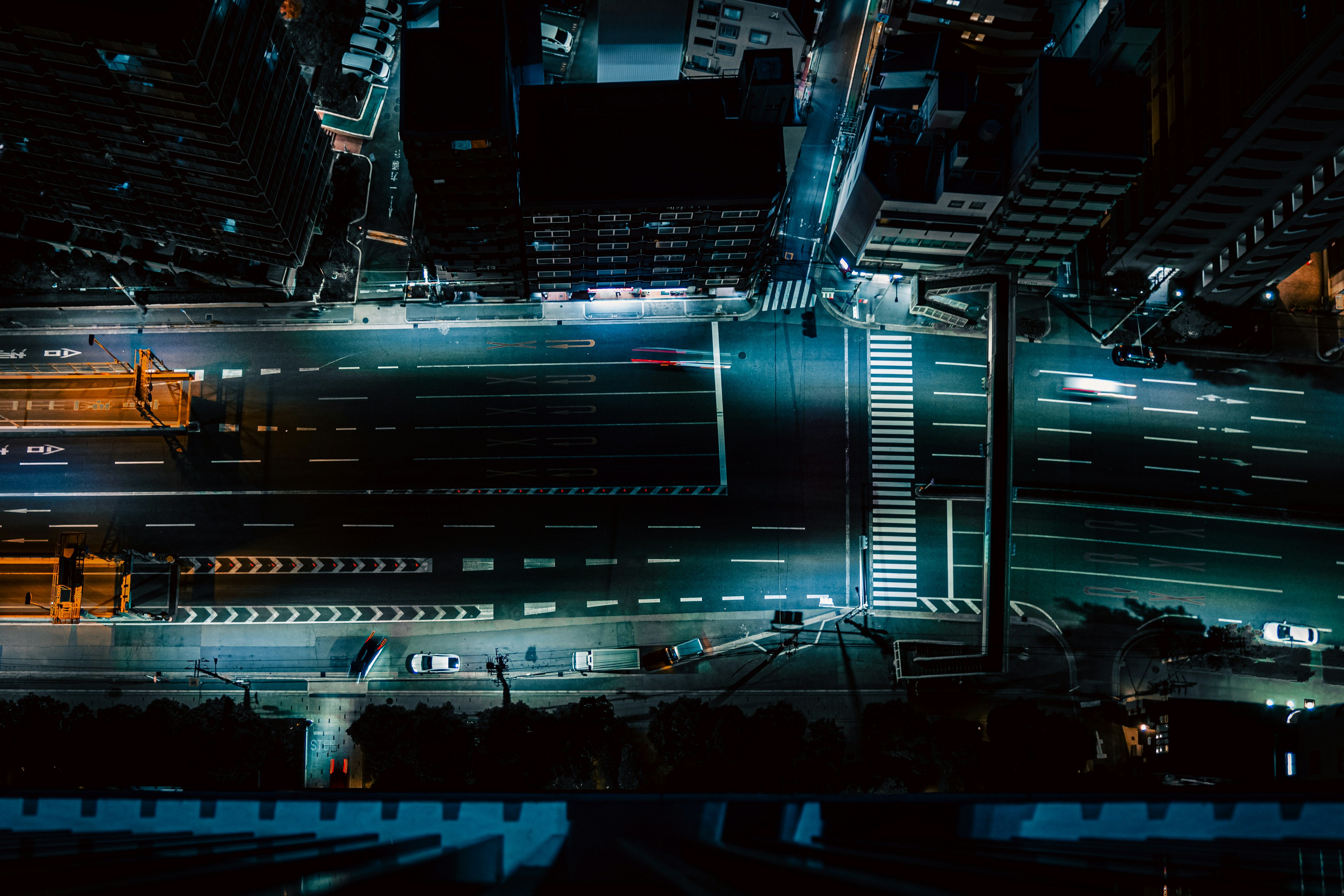 Aerial view of a city at night with illuminated roads and buildings in blue light